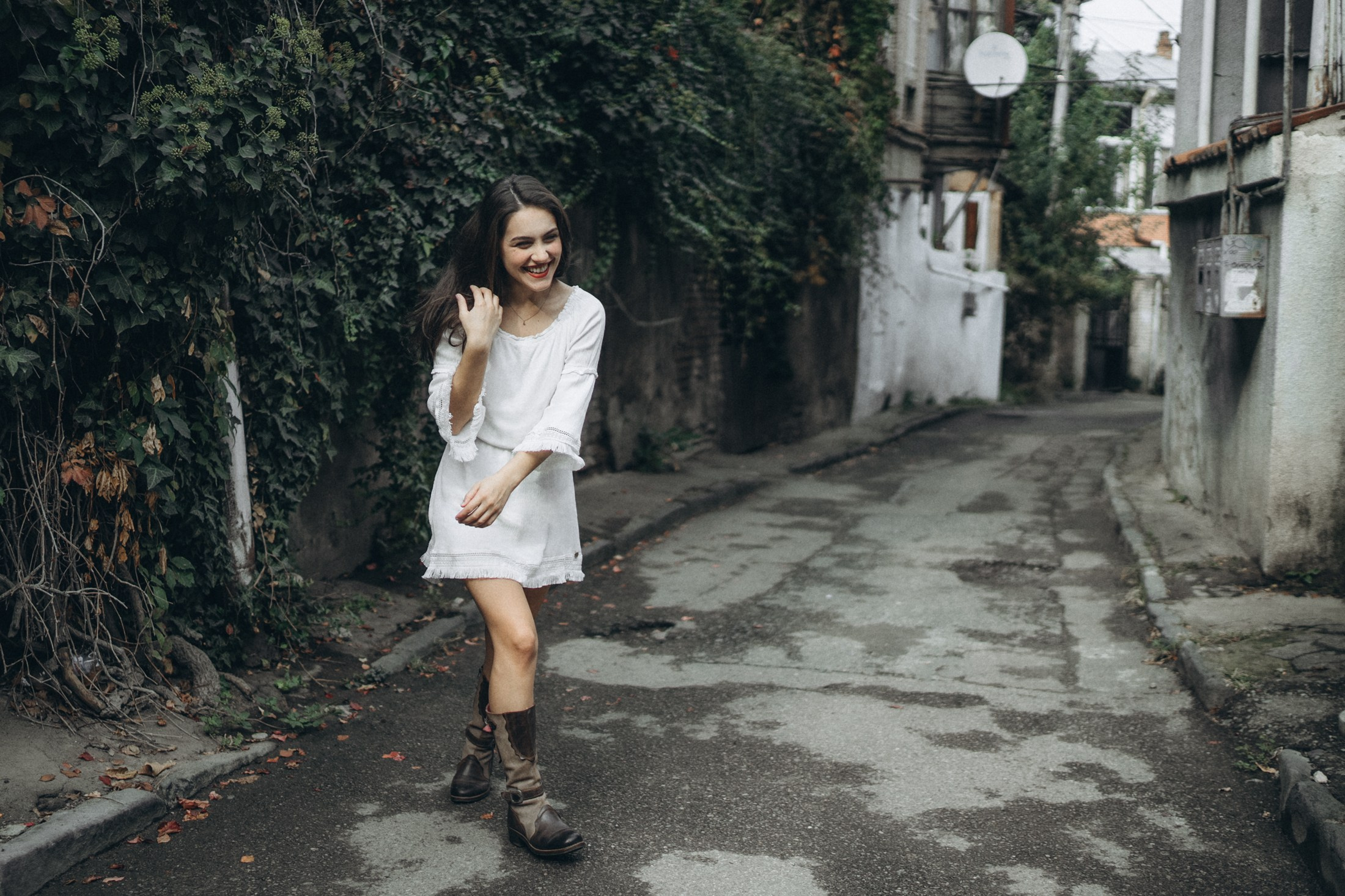 Frau in weißem Kleid geht durch eine schmale Gasse – authentisches Portrait in Dresden