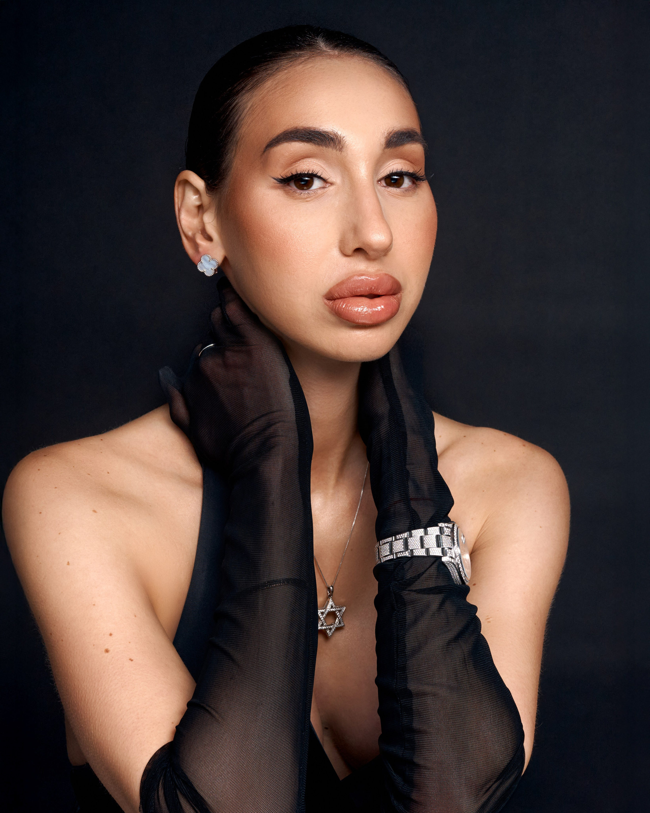 Luxury studio portrait on a black background, emphasizing facial expression, natural beauty and a strong personal presence.