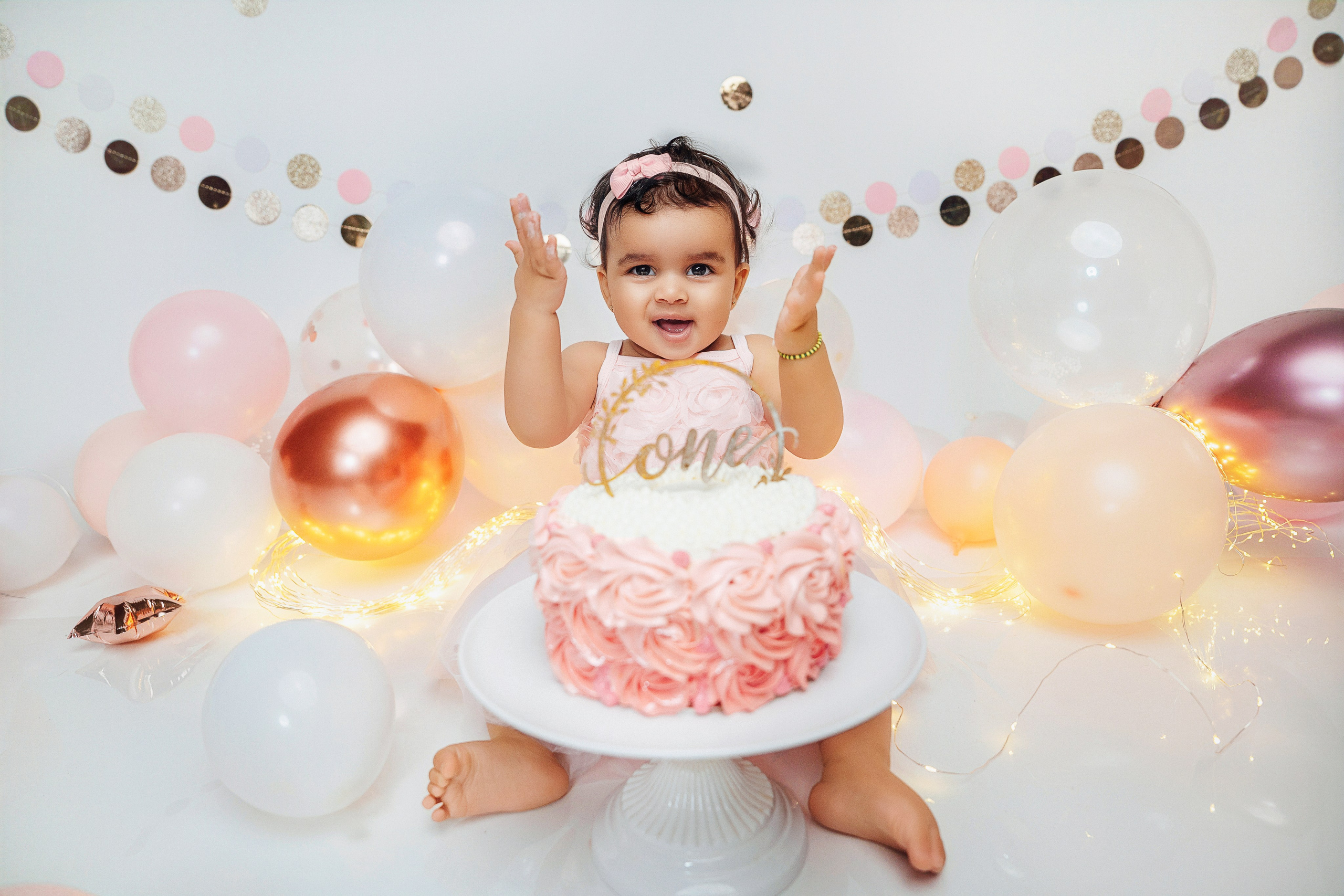 Профессиональная съёмка Cake Smash с годовалой девочкой в светлой и уютной атмосфере.