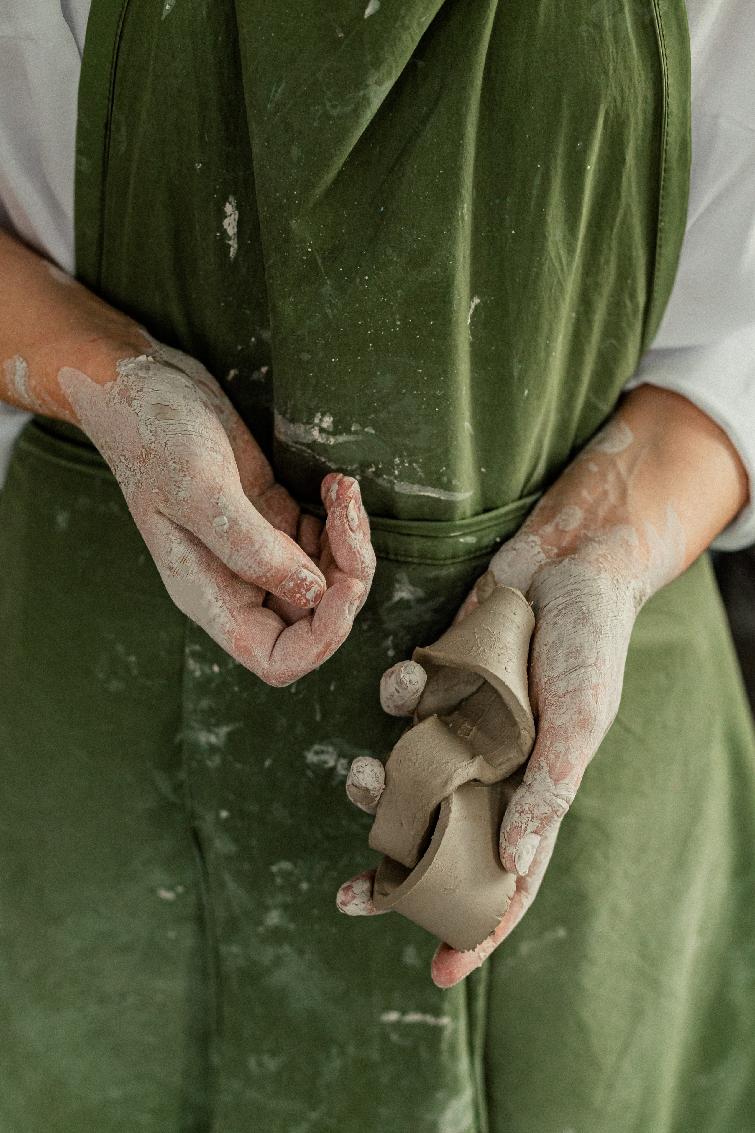Un ceramista sostiene trozos de arcilla en sus manos