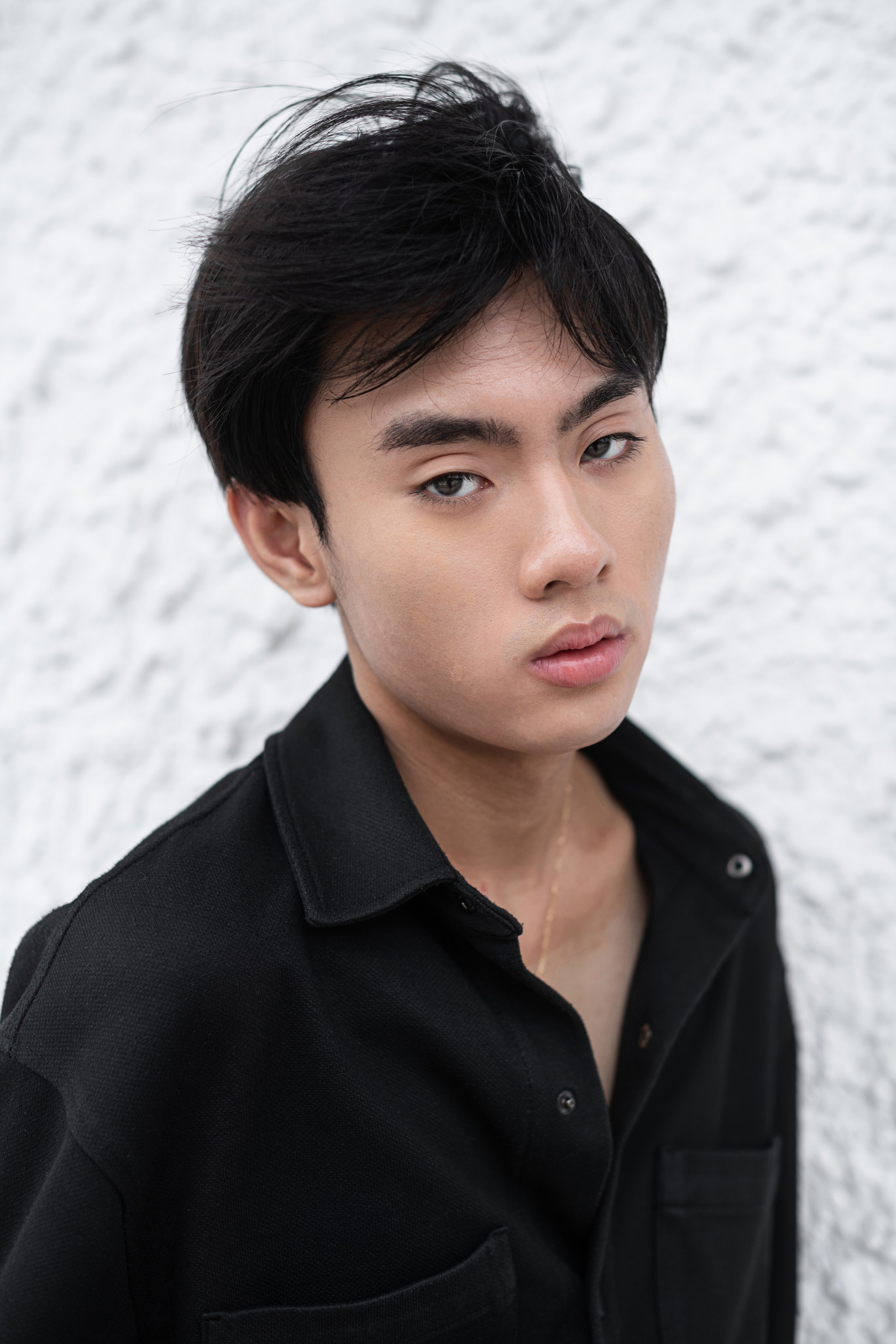 Vibrant fashion portrait of a male model with edgy styling and dramatic lighting in an urban Singapore setting.