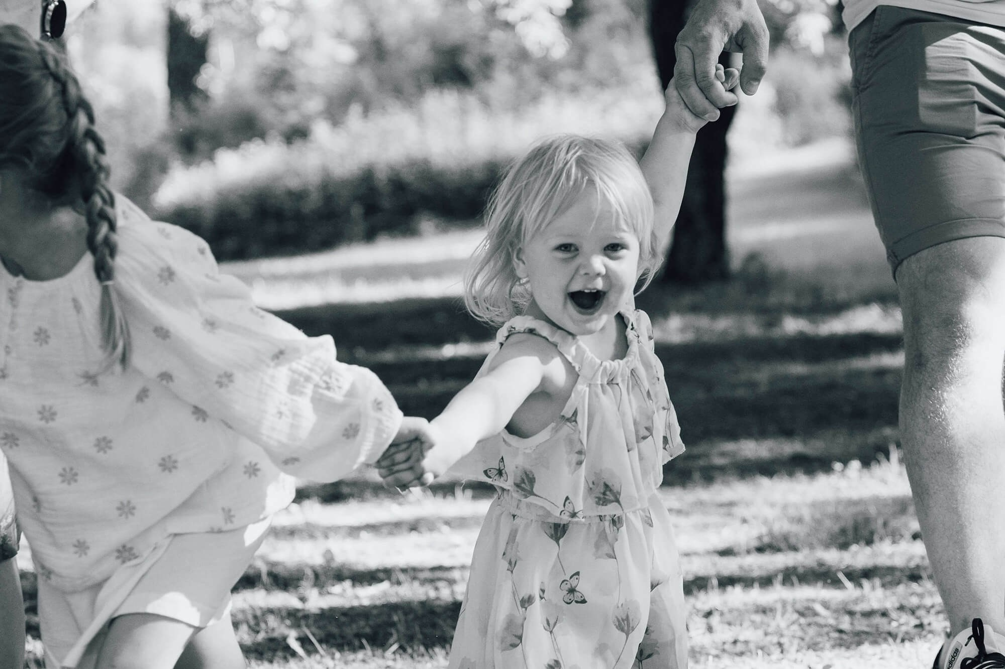 Barn hopper og leker under familiefotografering i parken