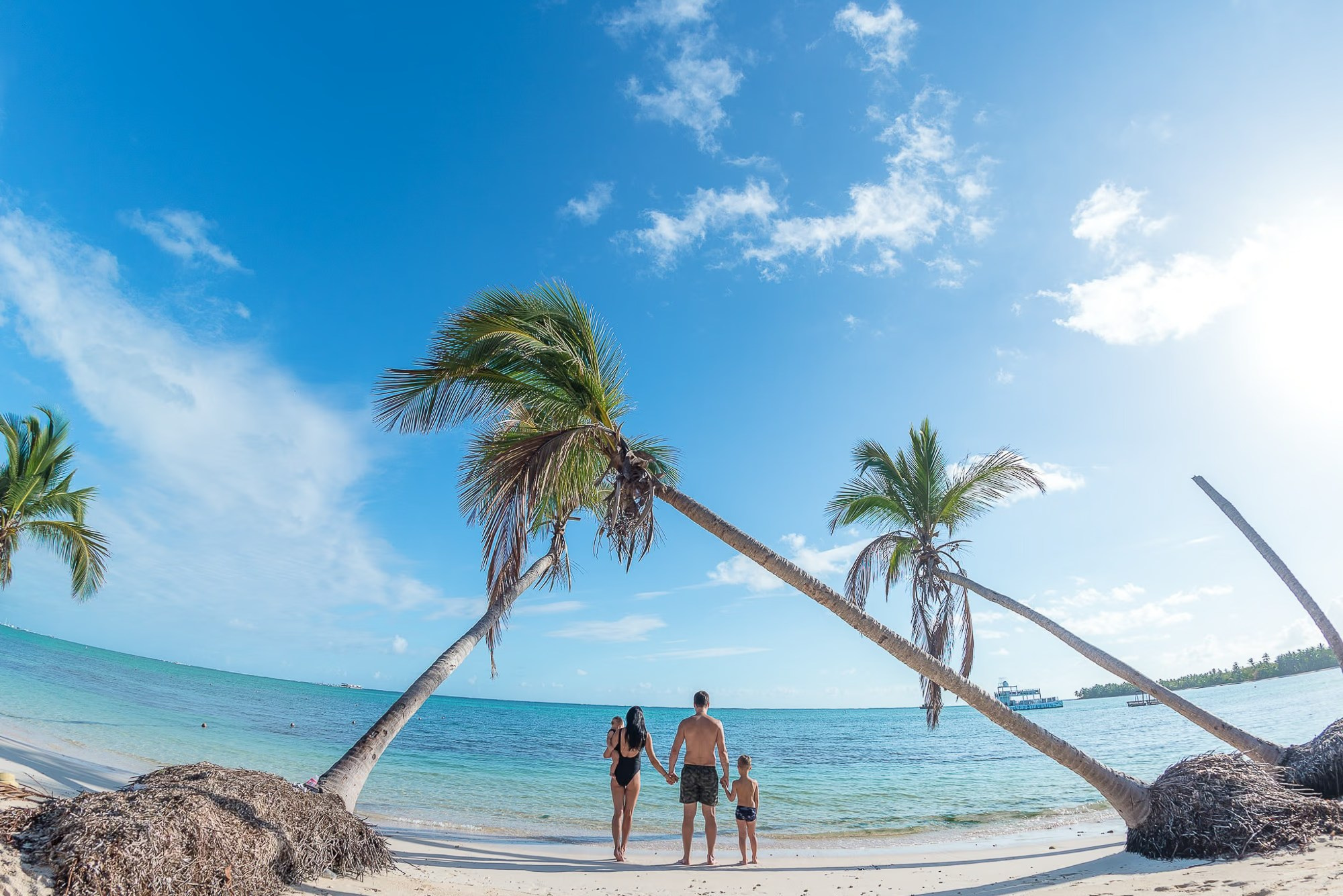Family laughing together by the turquoise Caribbean Sea in Punta Cana.