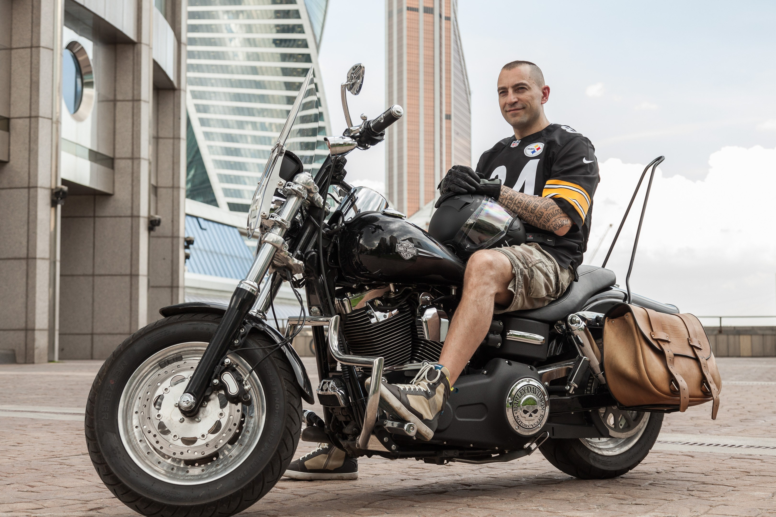 Location portrait of a biker on a Harley Davidson motorcycle in city landscape - photographer Andrey Dunin