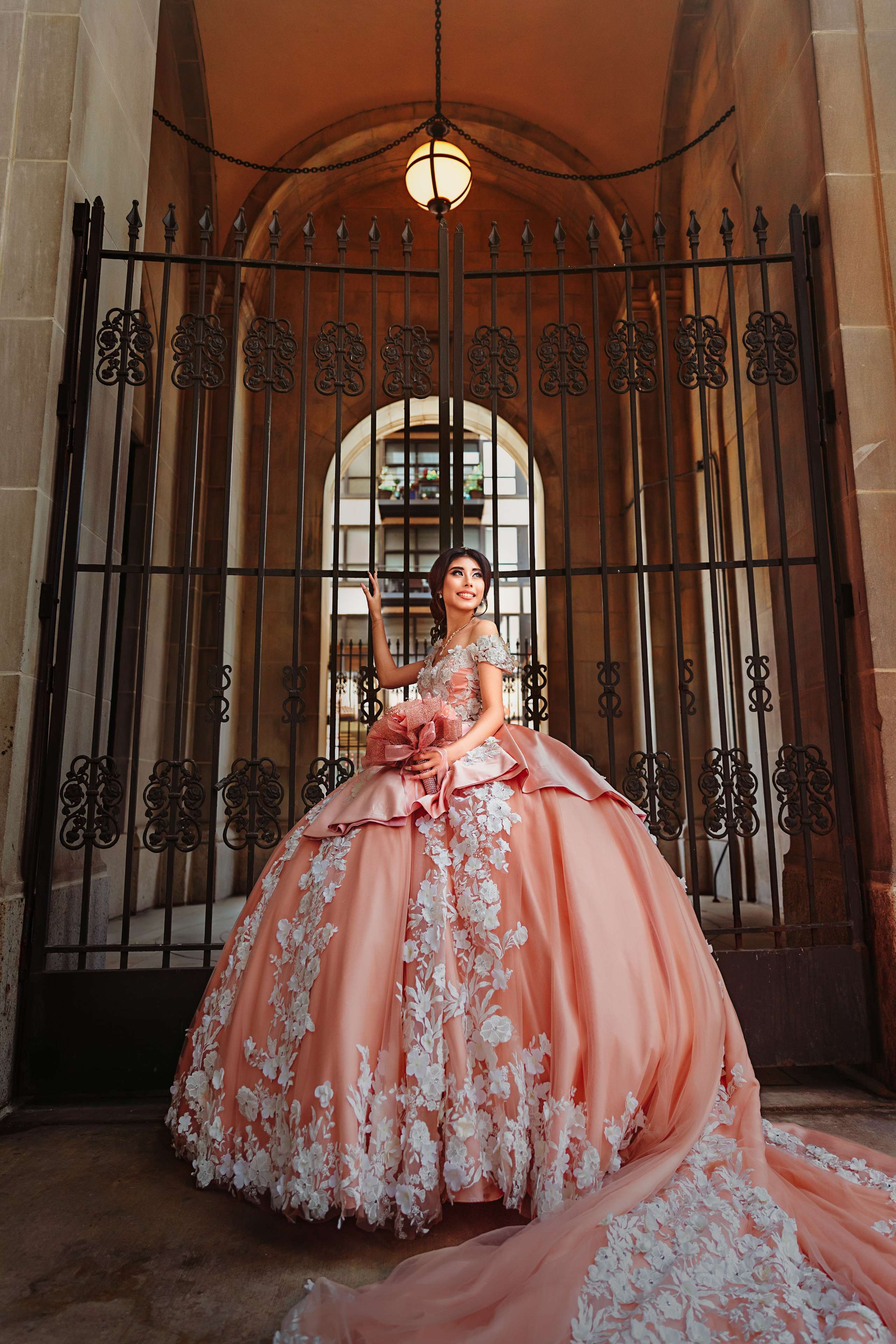 Majestic quinceanera portrait framed by historic wrought iron gates