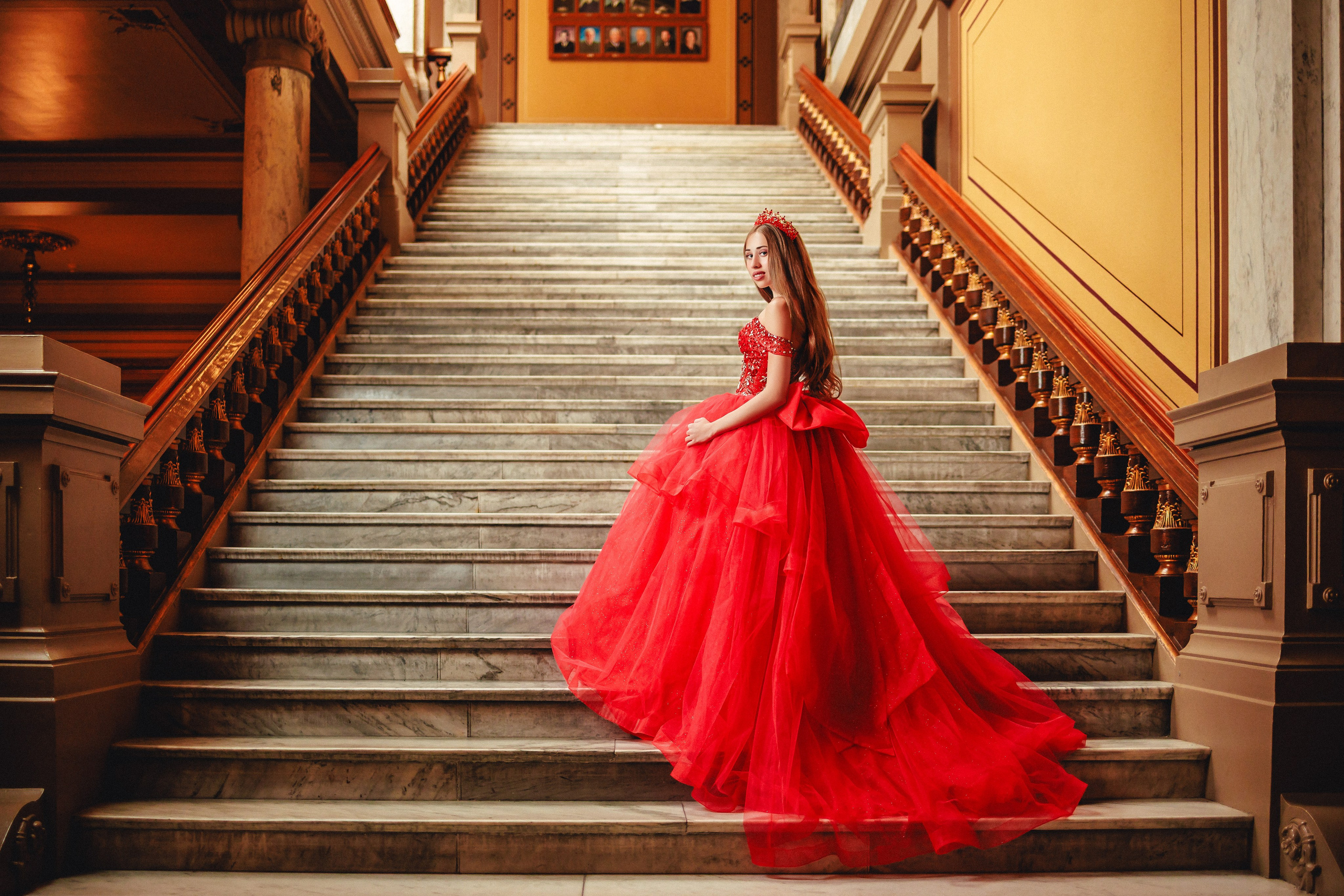 Cinematic quinceañera photoshoot on historic grand staircase in red gown