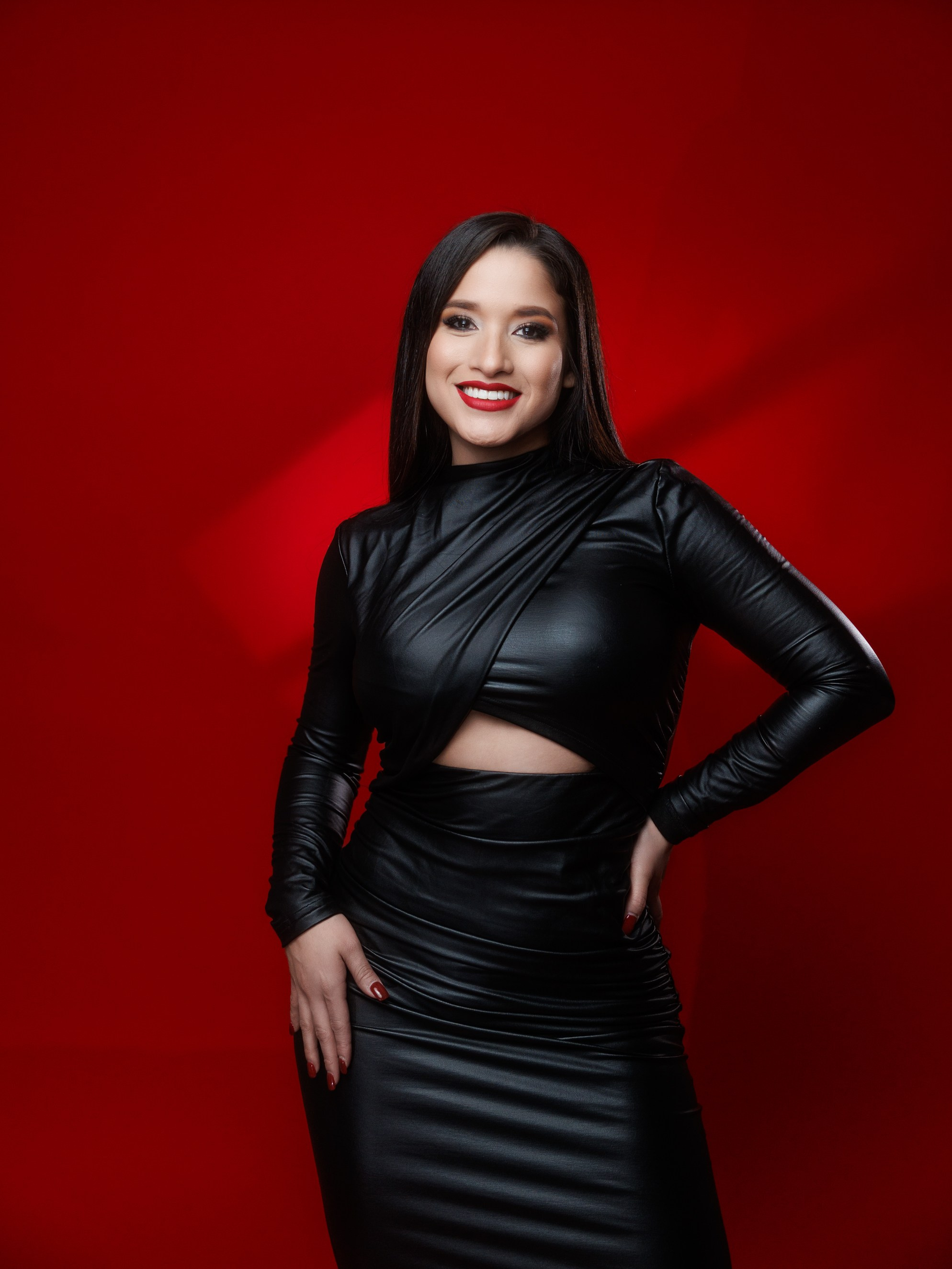 Full body editorial portrait on vivid red seamless background in studio