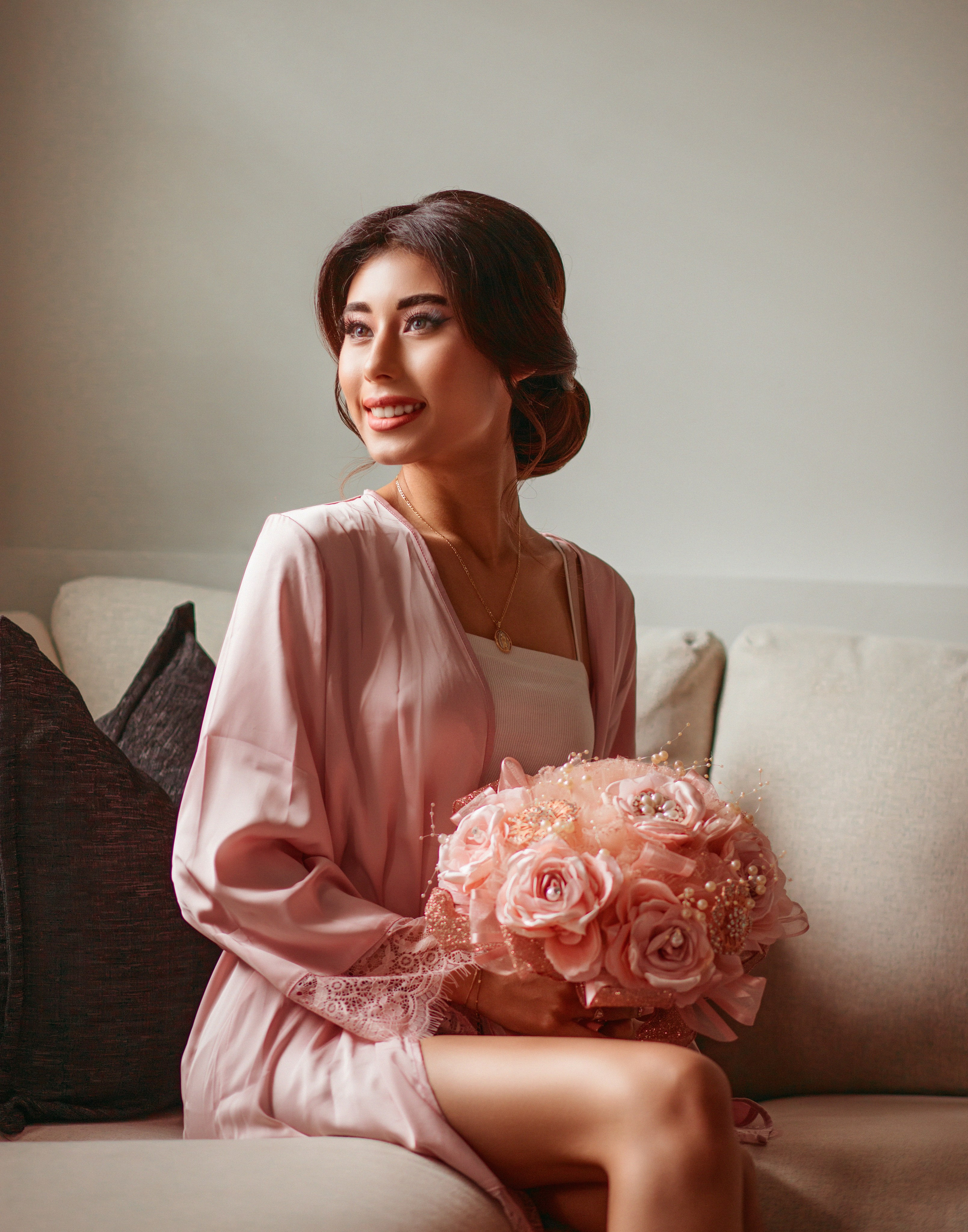 Fine art getting ready portrait of quinceanera holding peach bouquet