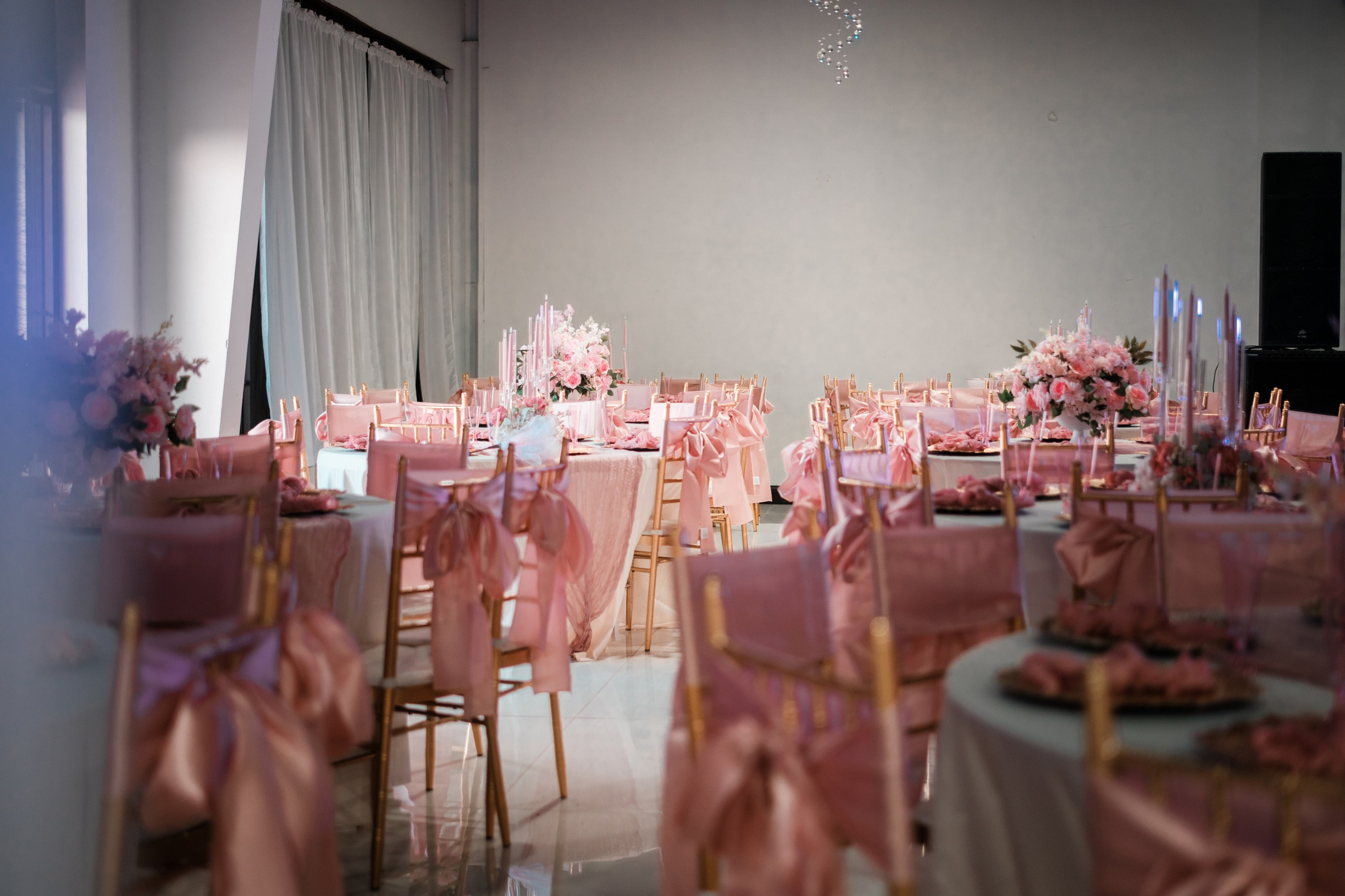 Ballroom reception setup with pink satin chair sashes at Star Events