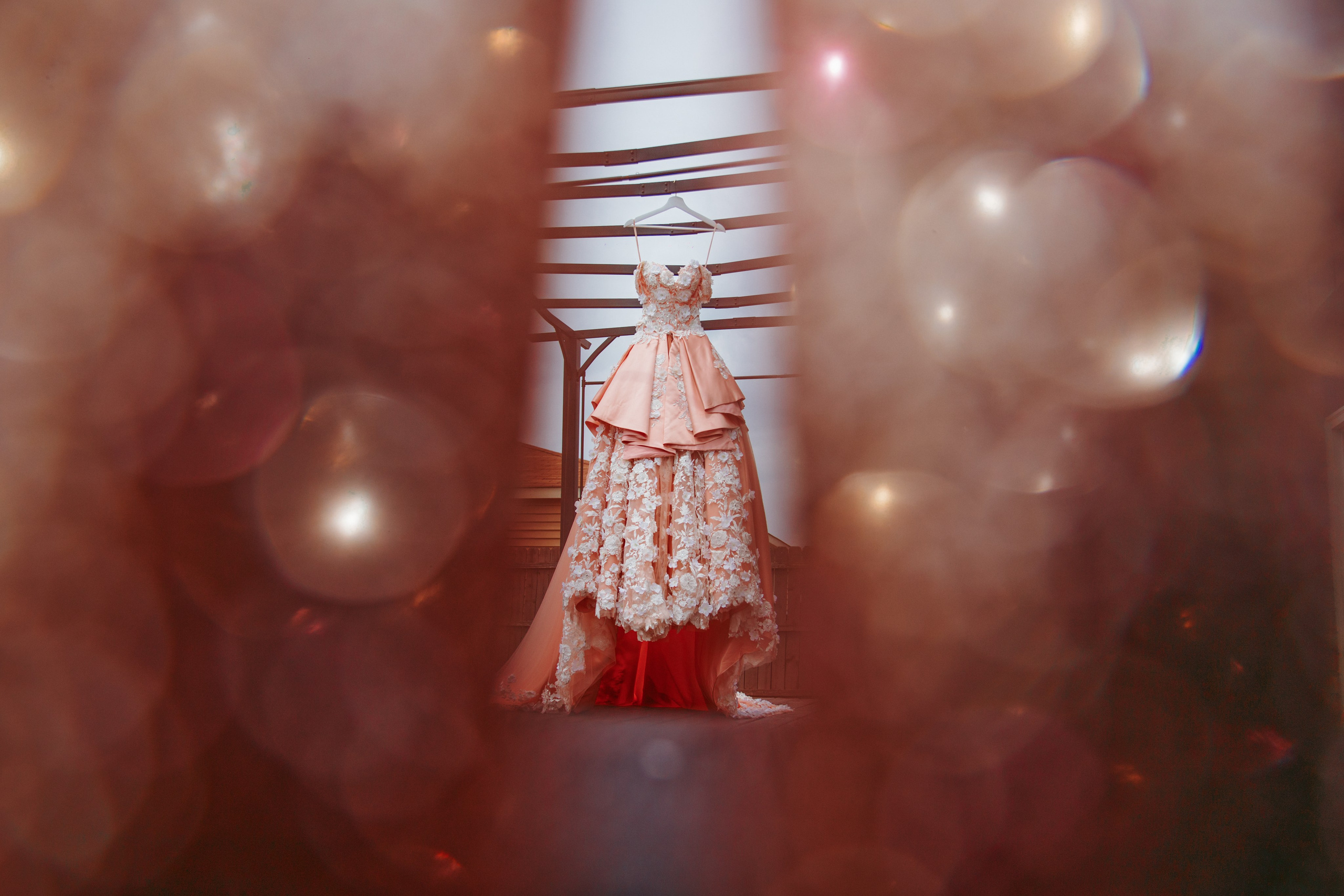 Blush floral quinceanera gown with dreamy foreground bokeh framing