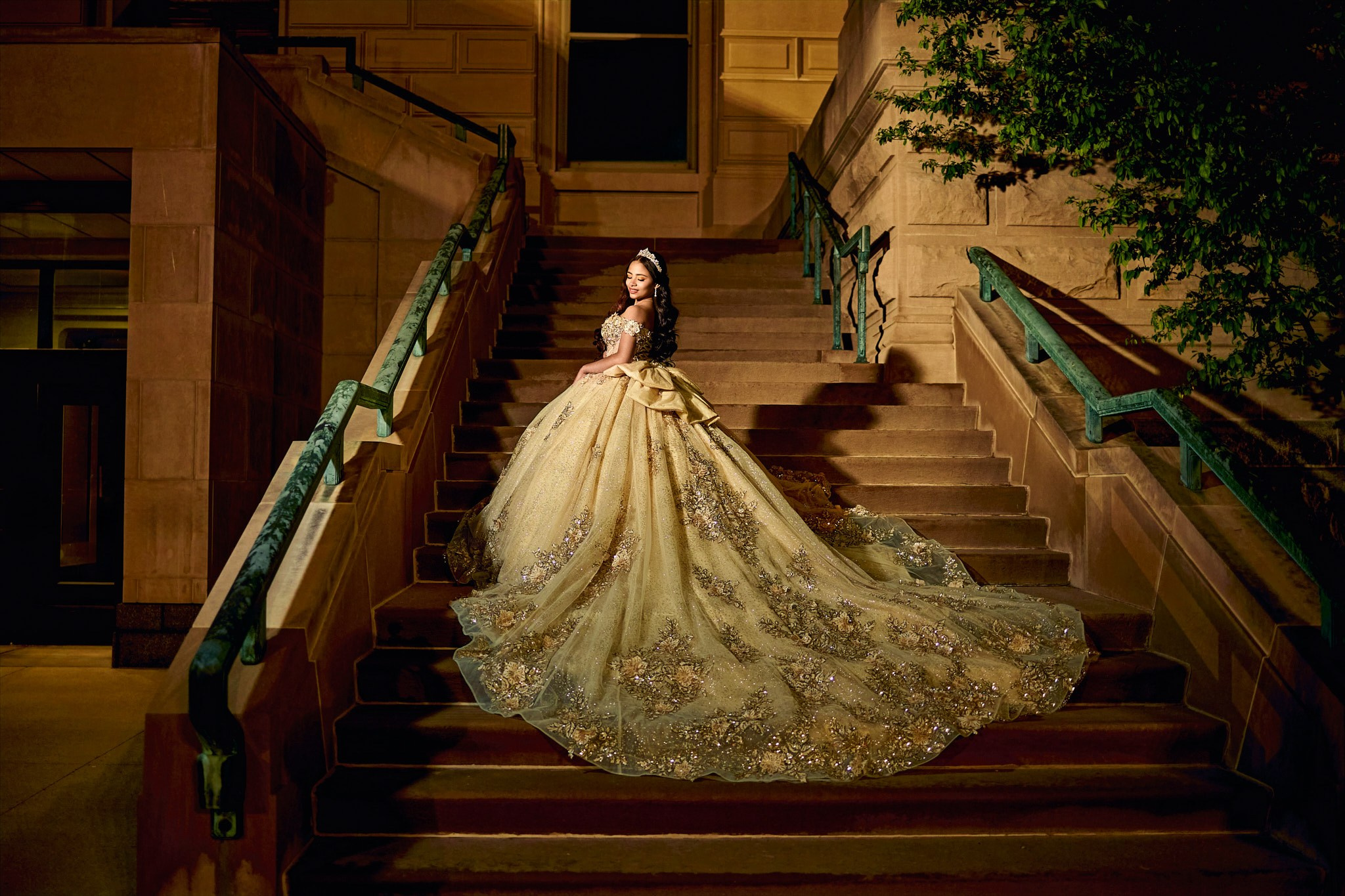 Dramatic fine art quinceañera portrait in sweeping golden gown on grand staircase Indianapolis