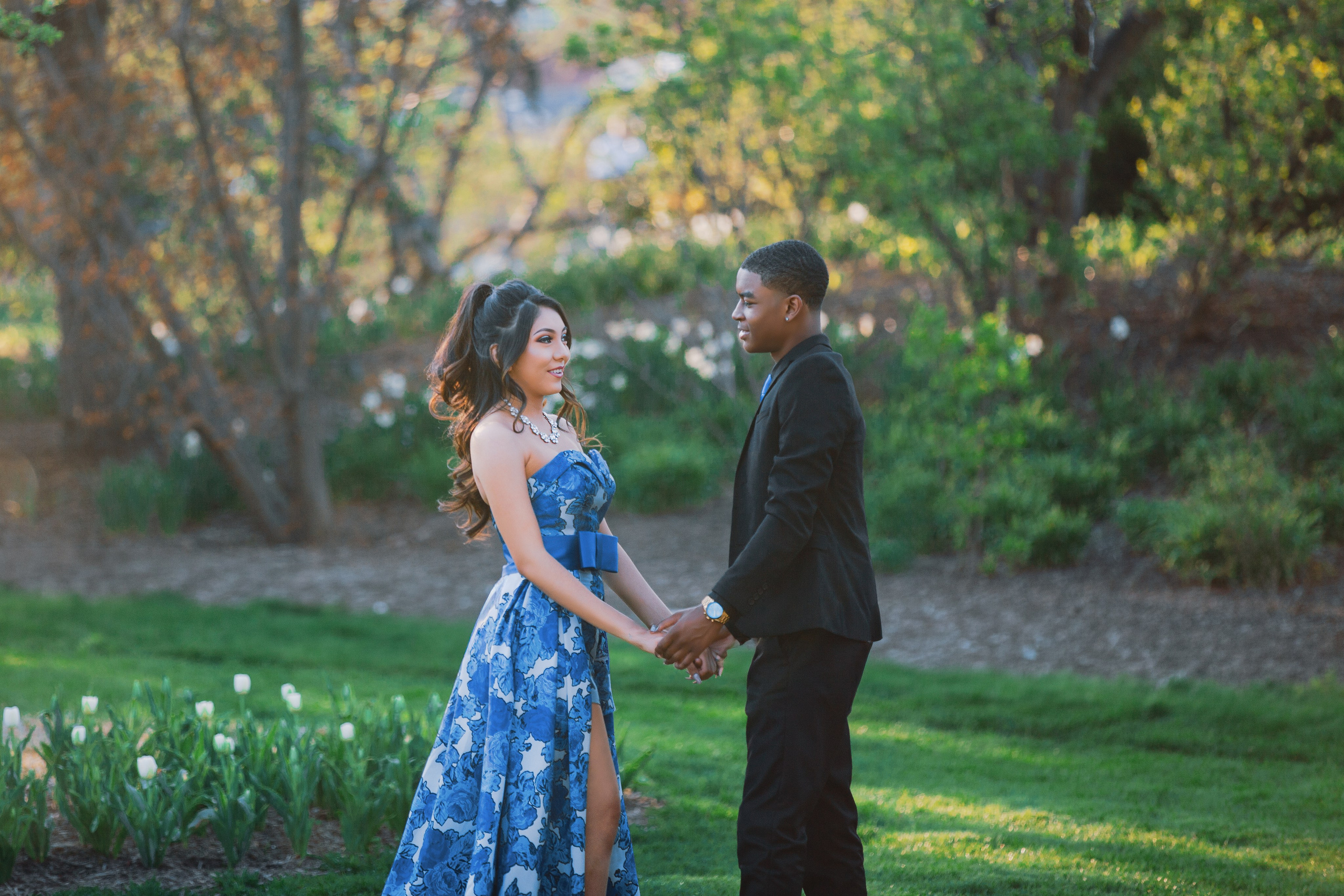 Romantic couple holding hands in garden during golden hour portrait session by Gabby Aguirre Photography