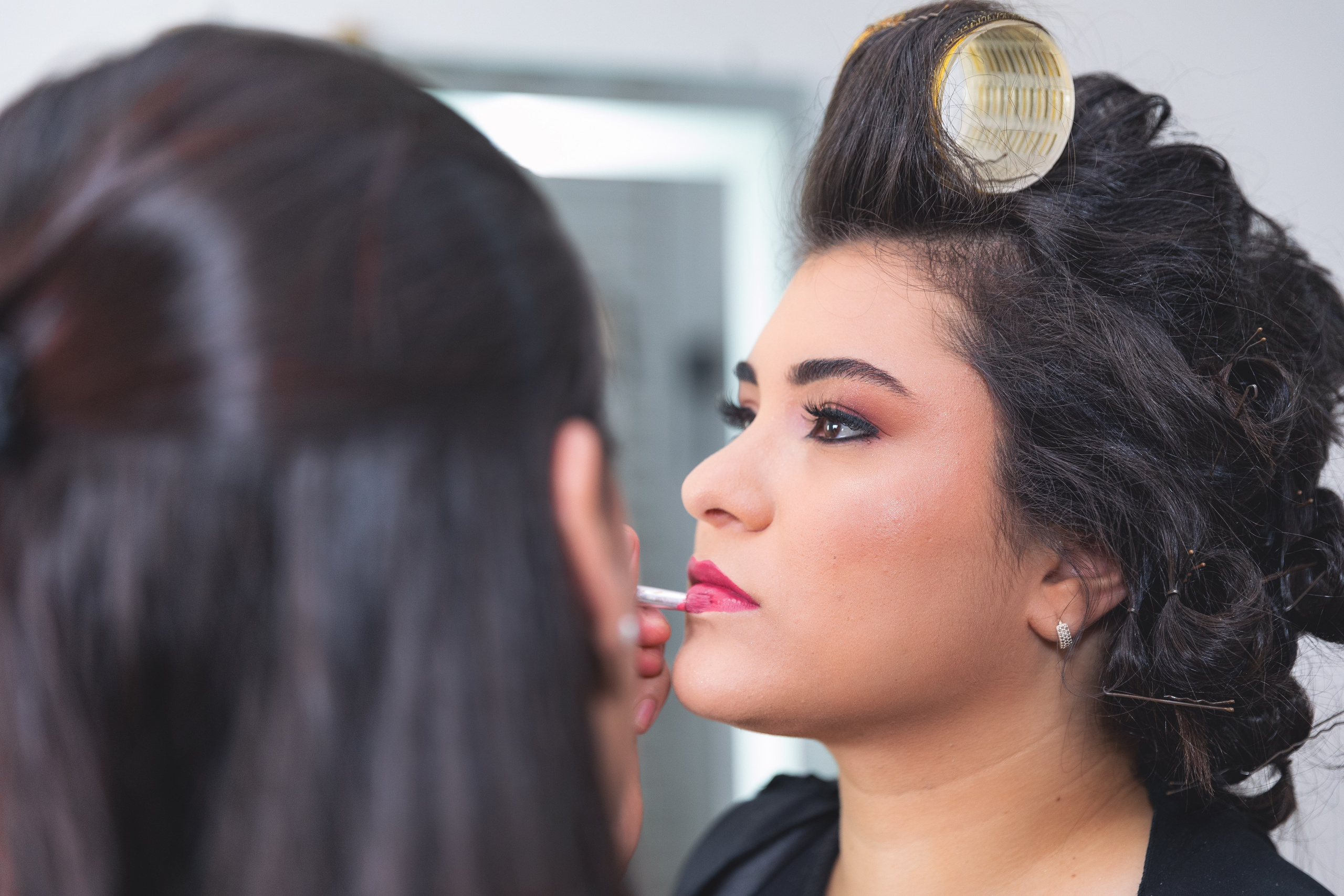Uma fotografia de making-of da noiva em curitiba, finalizando sua maquiagem antes de subir o altar