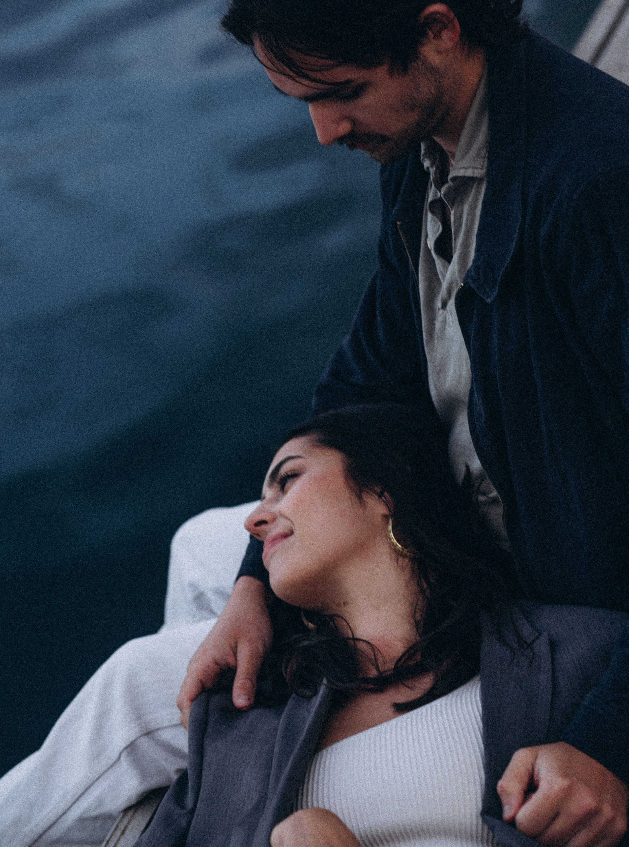 Tender love story couple photo captured in Benidorm, Spain — showcasing a serene moment by the sea as the woman rests her head on her partner’s lap, ideal for those searching for natural and emotional couple photoshoots in Benidorm and across Spain.