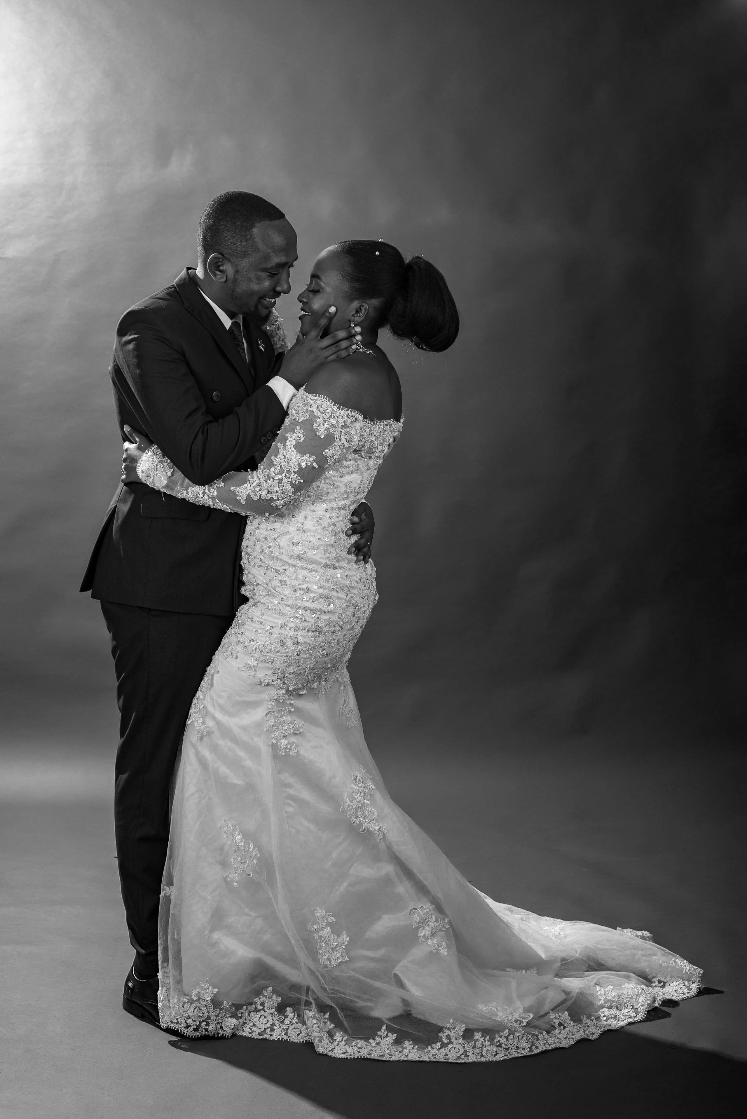 A black and white studio portrait of a bride and groom 