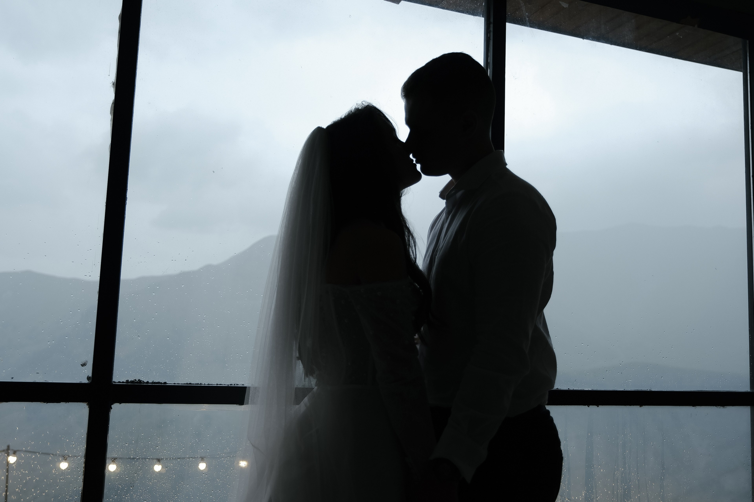 Couple silhouette by window in mountains