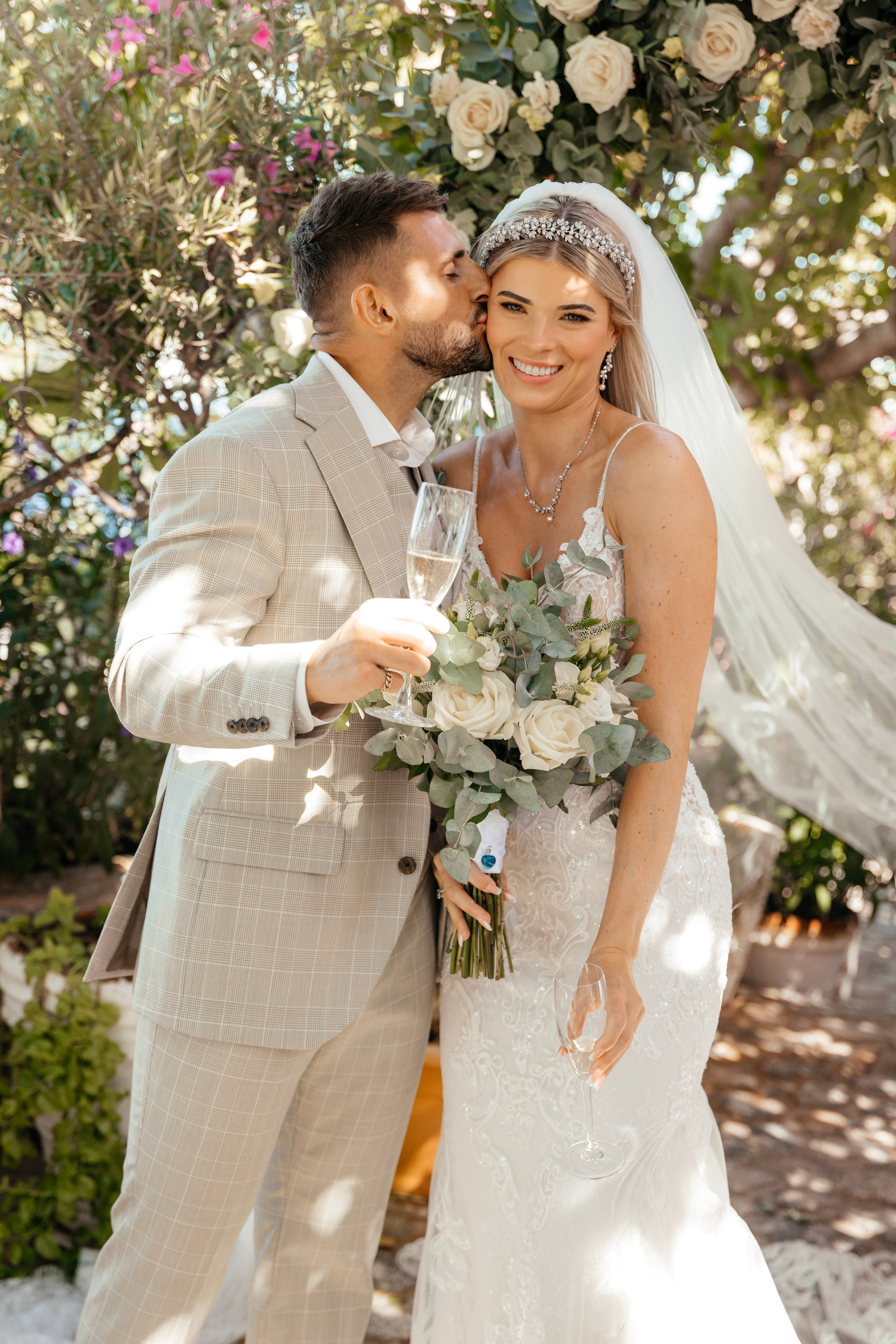 The groom is kissing the bride after the wedding ceremony in Lindos, Rhodes, Greece