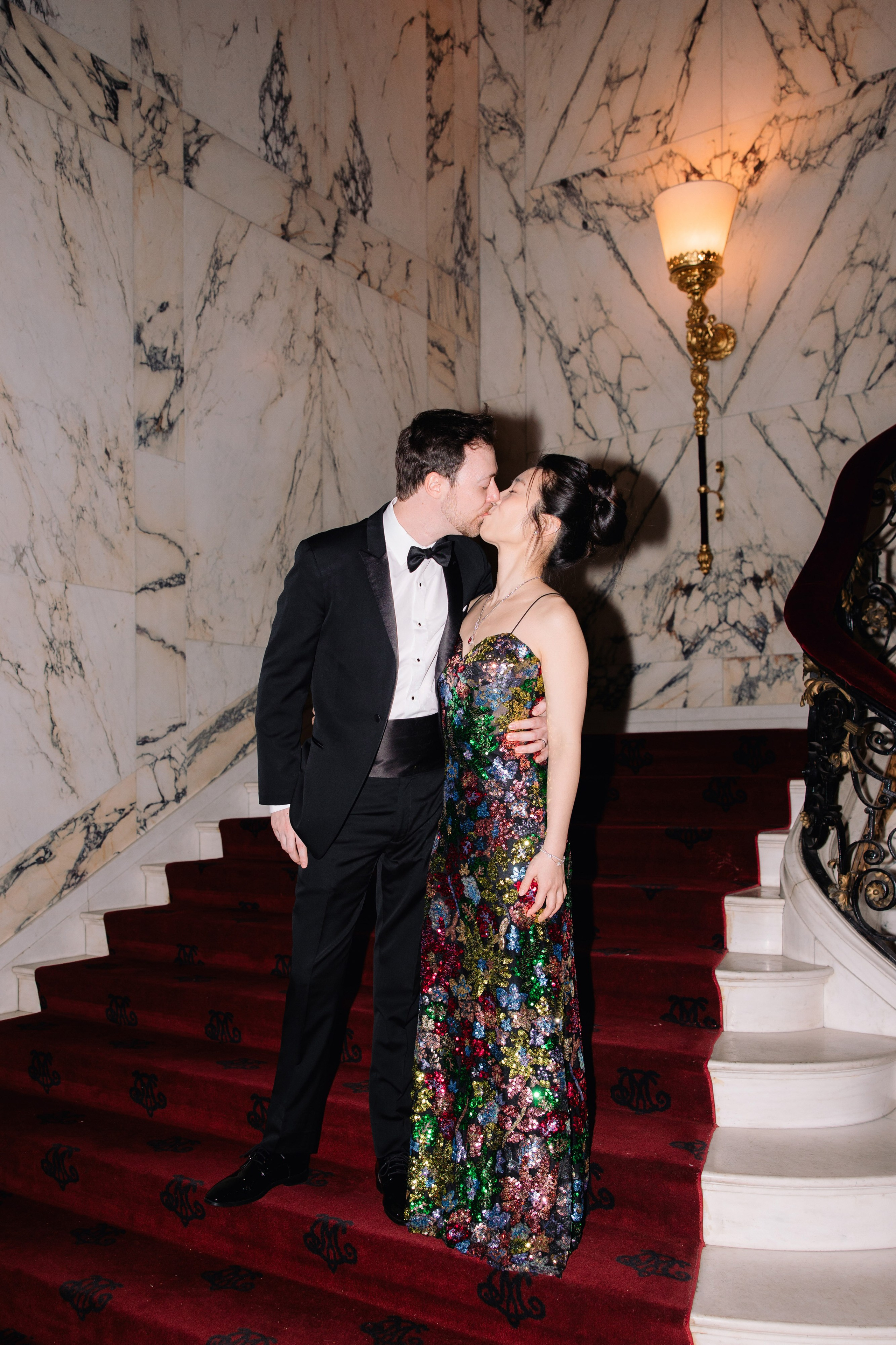 a man and woman kissing on a red carpet