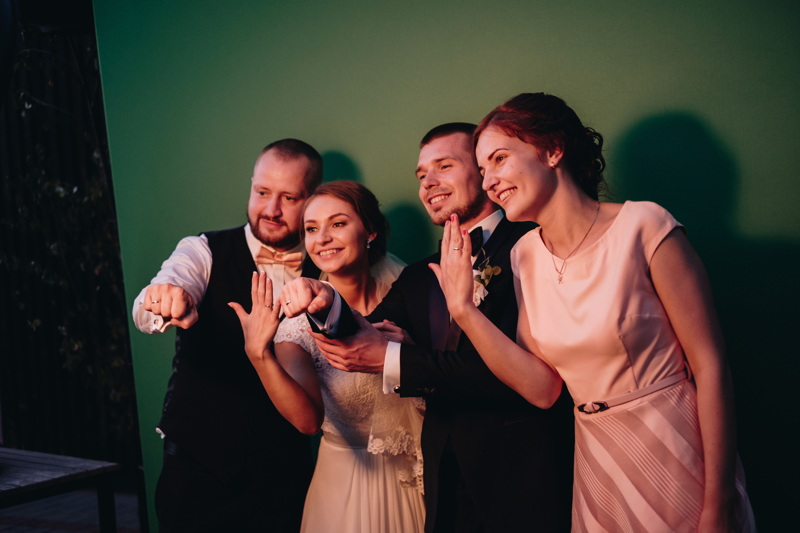 Jaunais pāris ar lieciniekiem fotografējas pie foto kastes kāzās. prieks. 