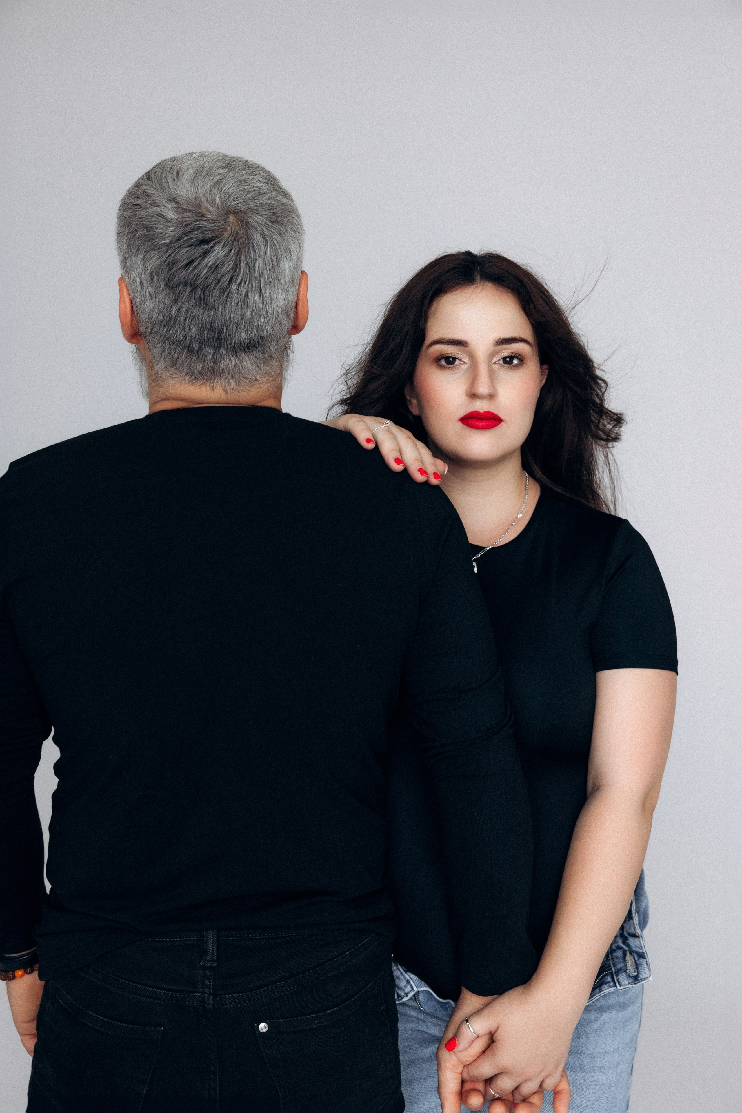 Kontrast i napięcie – partner odwrócony, kobieta patrzy w kamerę, fotografia ciążowa z charakterem.