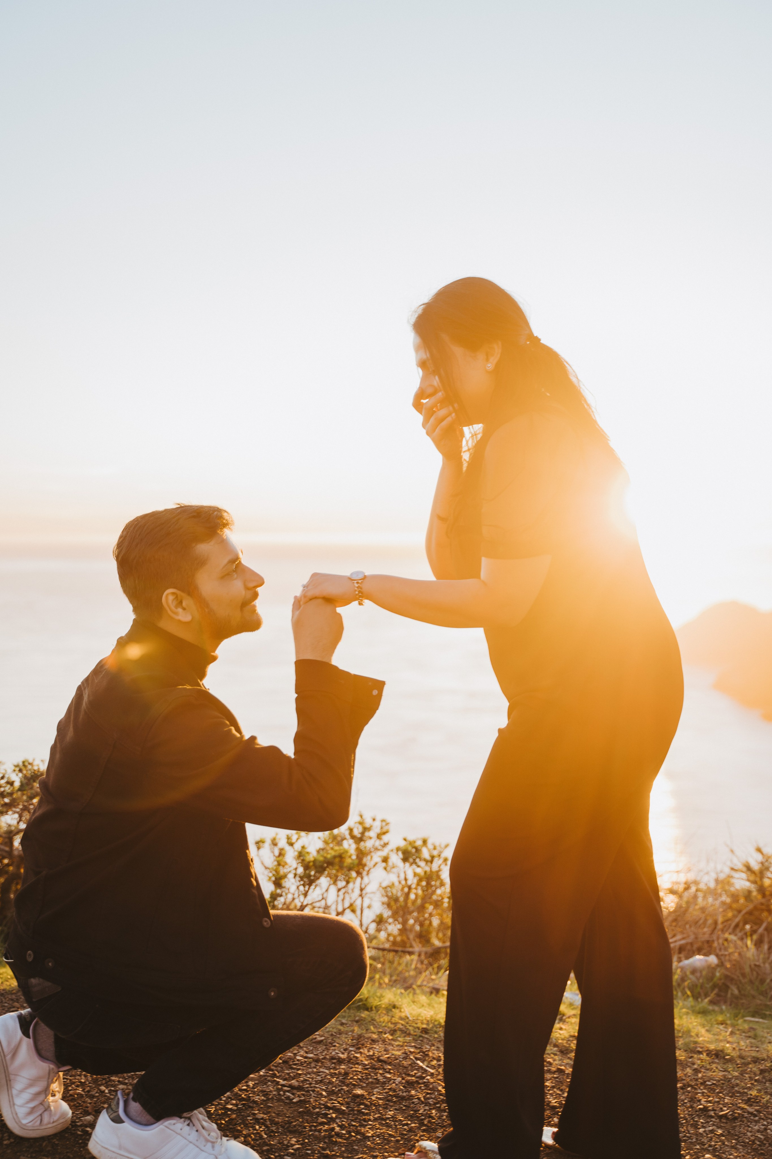 Proposal.  Overlooking the golden San Franisco Bridge sunset with a couple. Photographer Video. 