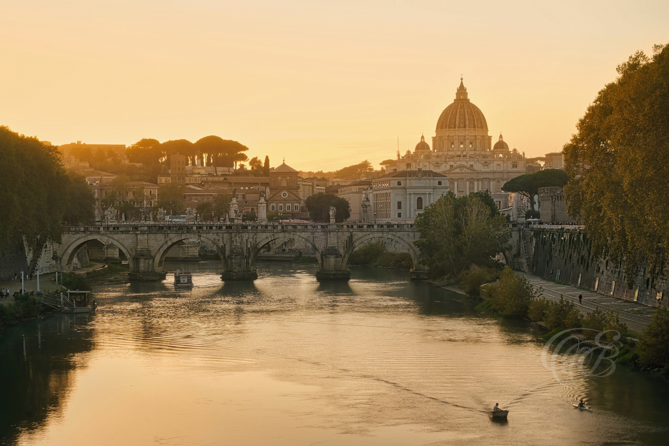 Rome, Italy — This photograph frames Ponte Sant’Angelo in alignment with the distant dome of St. Peter’s Basilica, capturing two landmarks rooted in the city’s layered religious and imperial history. Originally built by Emperor Hadrian in the 2nd century as a grand approach to his mausoleum, the bridge now leads toward the Vatican, crowned by Bernini’s statues of angels. The shot connects ancient Roman engineering with Renaissance theology, echoing Rome’s enduring dual legacy. Eduardo Bartoli Photography.