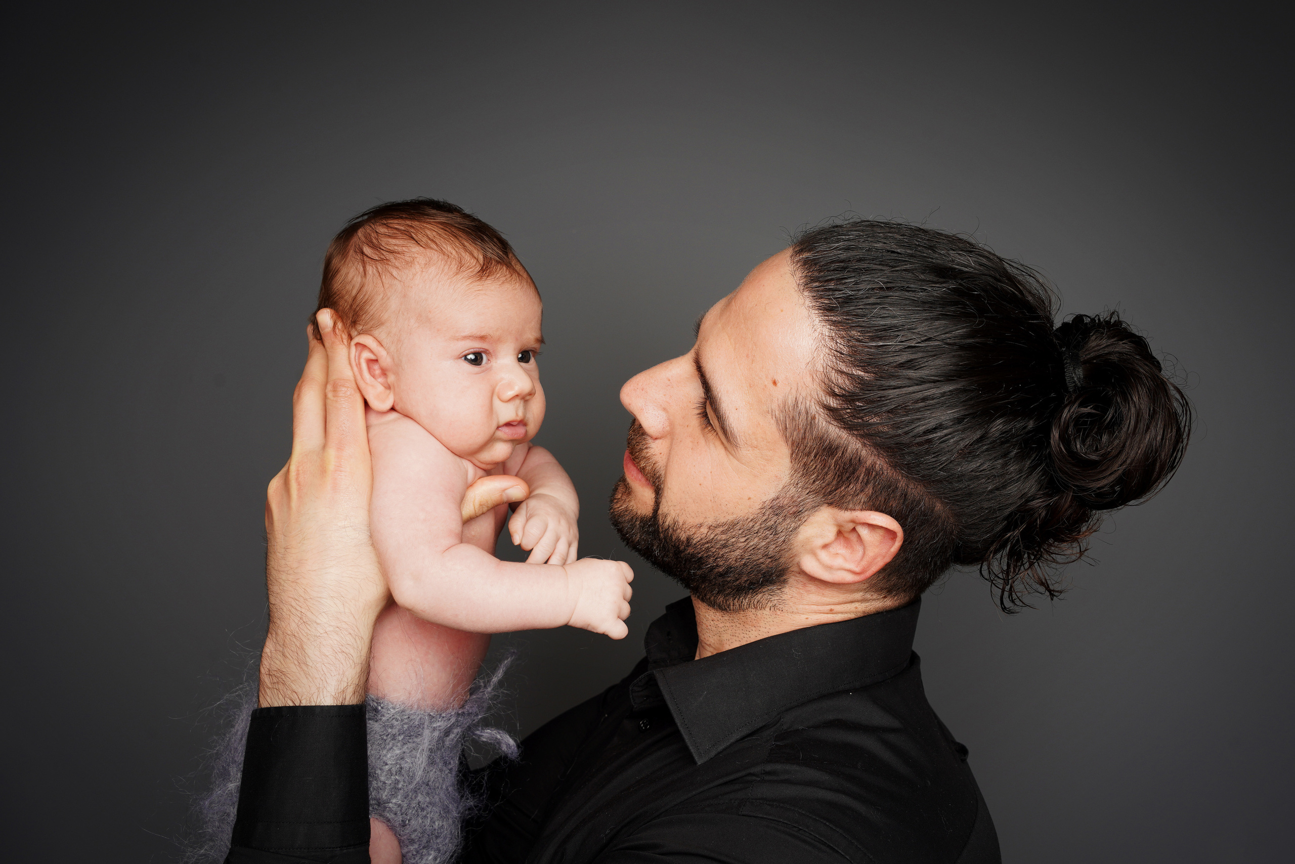 Das Baby in den sicheren Händen des Papas