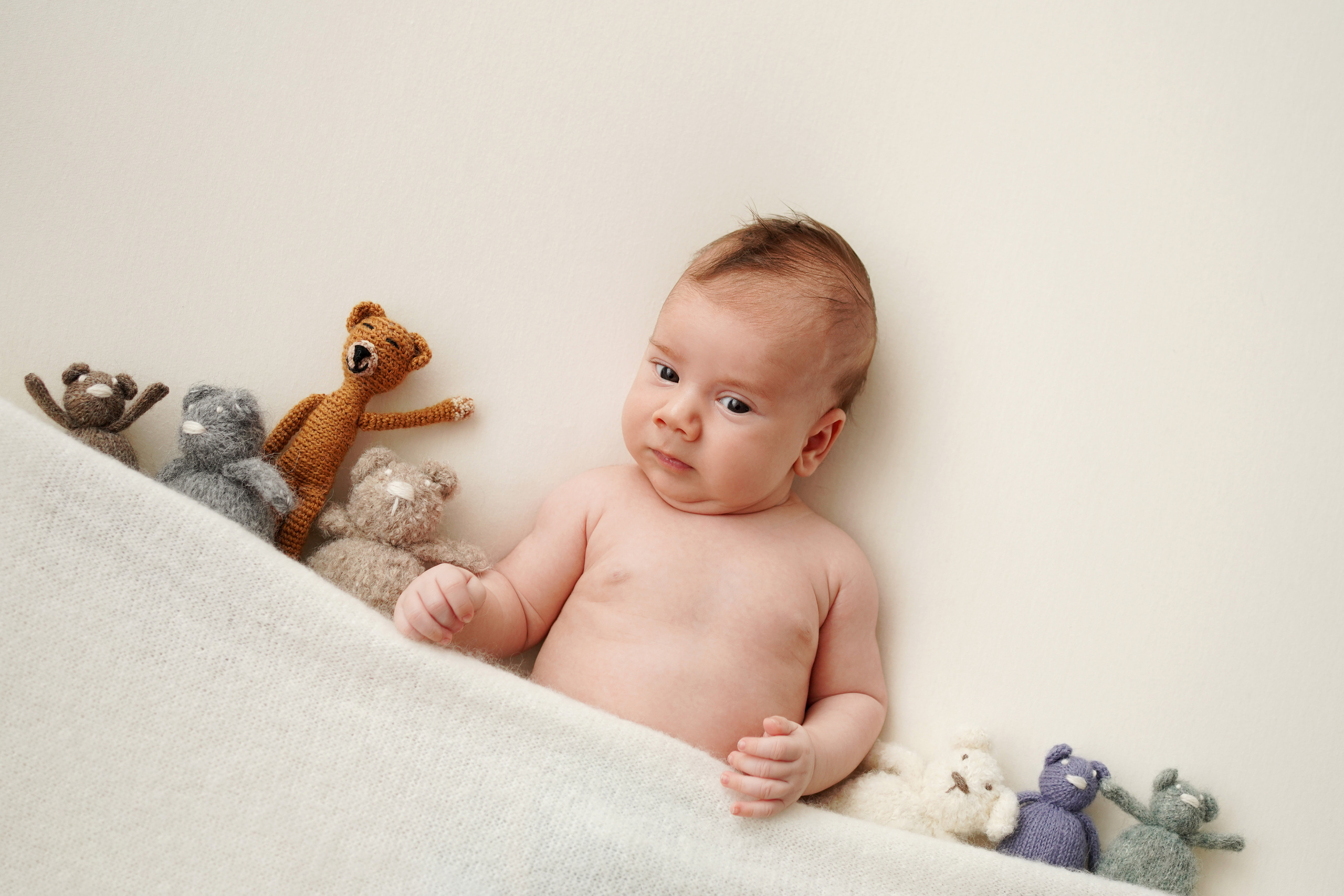 Das Baby in den Armen seines Lieblingskuscheltiers