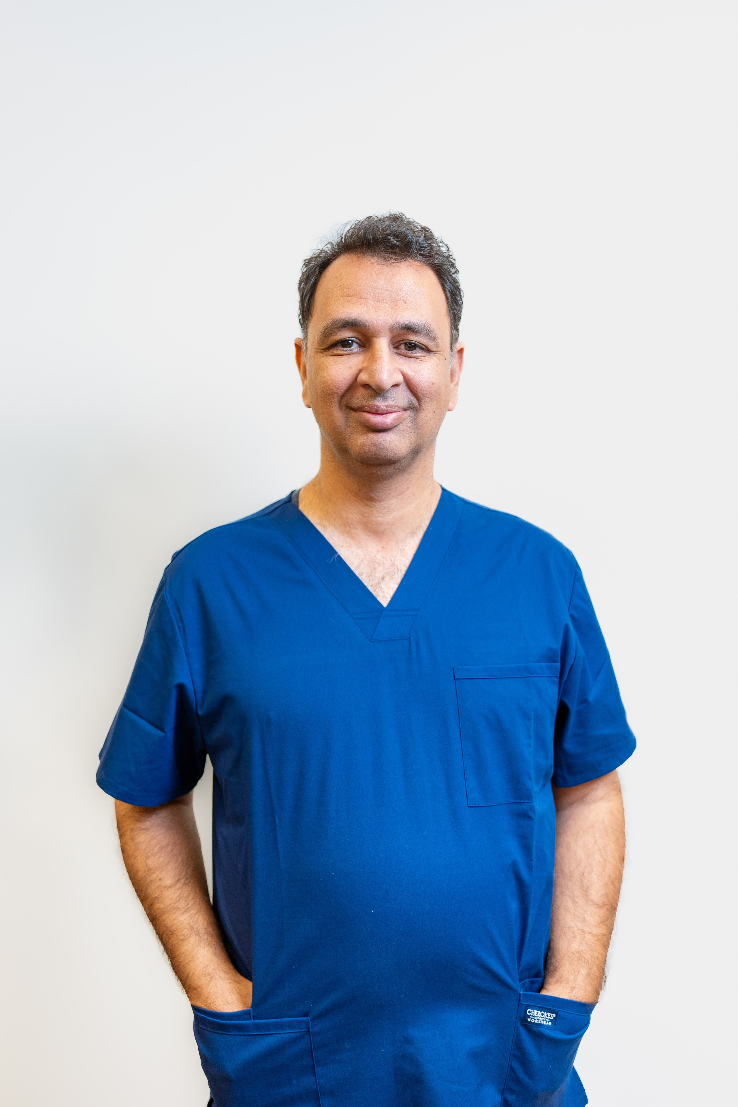 Smiling male doctor in blue scrubs