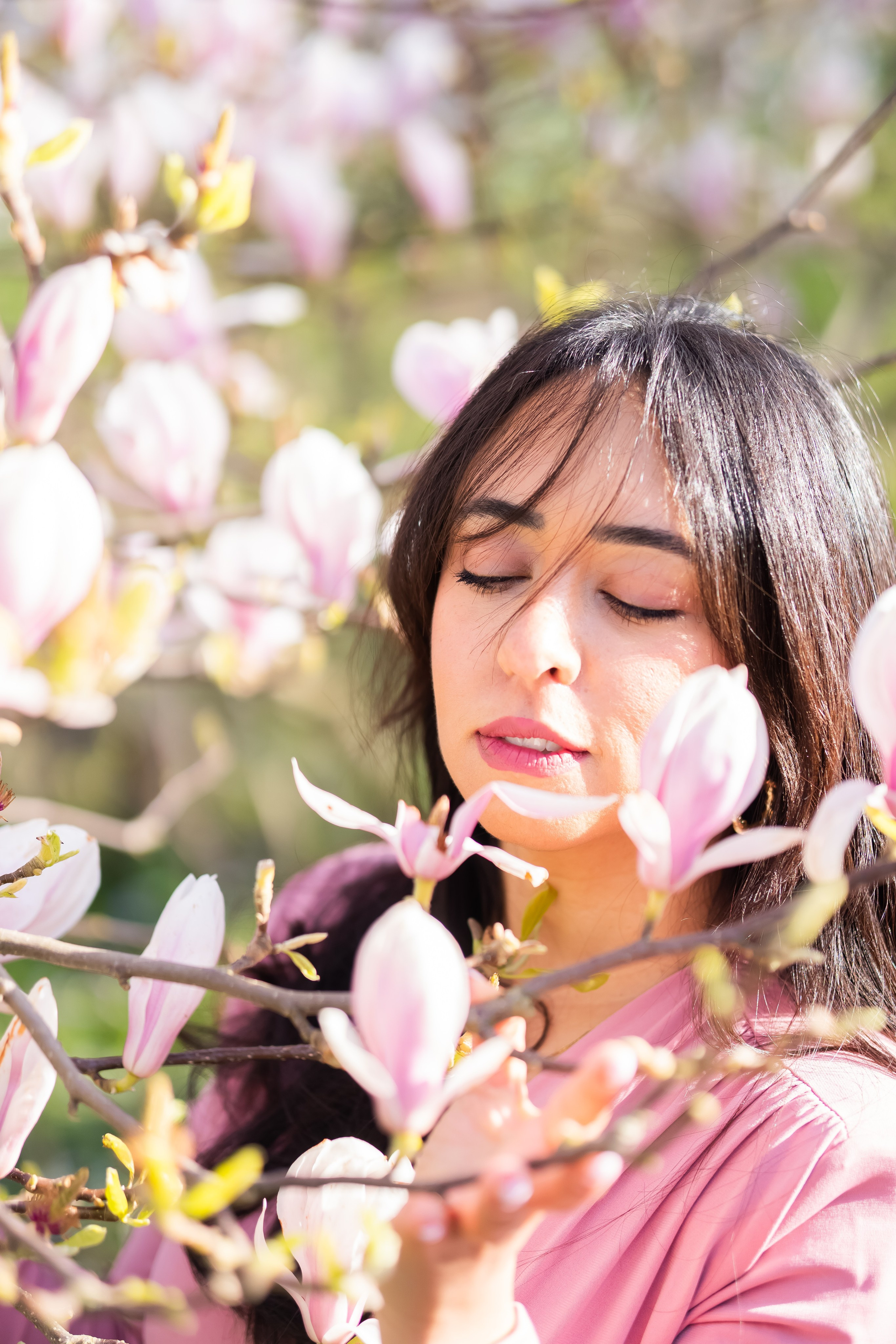 girl holding a magnolia branch in a garden in Netherlands