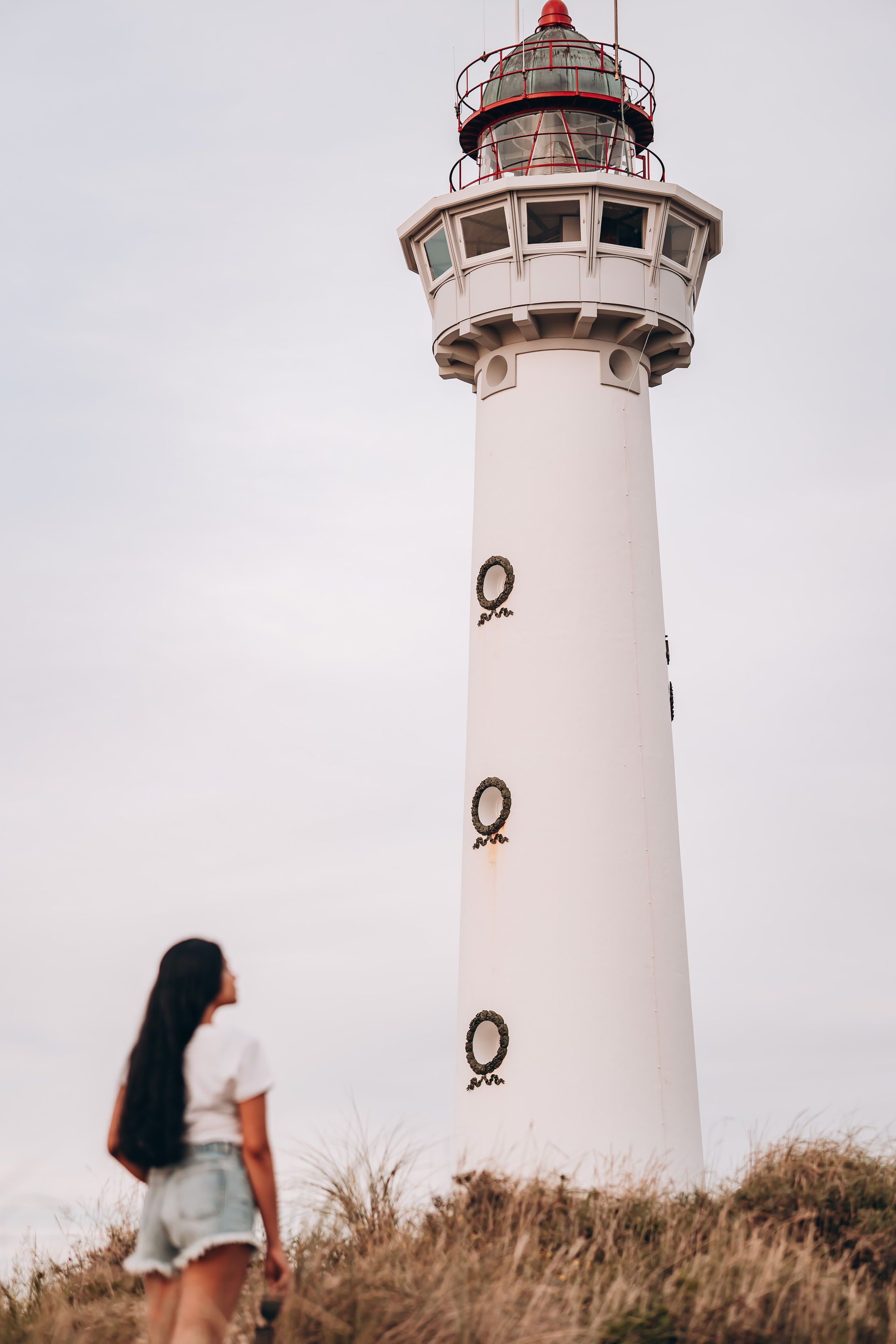 Woman standing in front of a lighthouse in the Netherlands