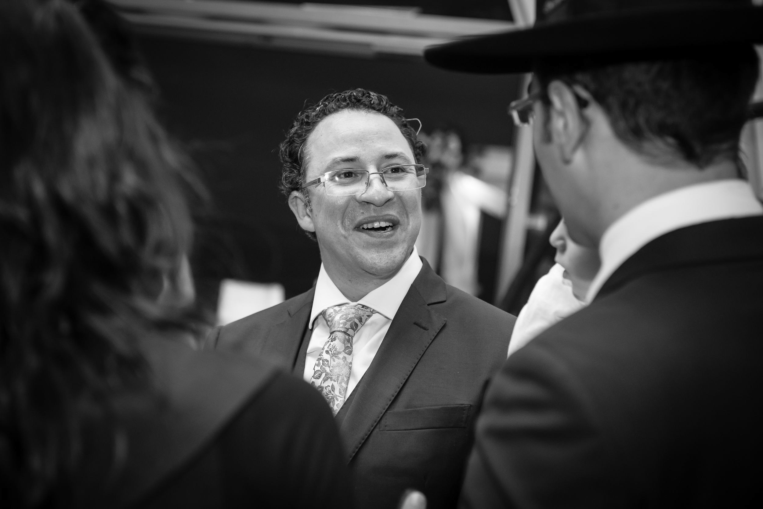 Groom Michael sharing a candid conversation with wedding guests during the reception in Haifa, Israel
