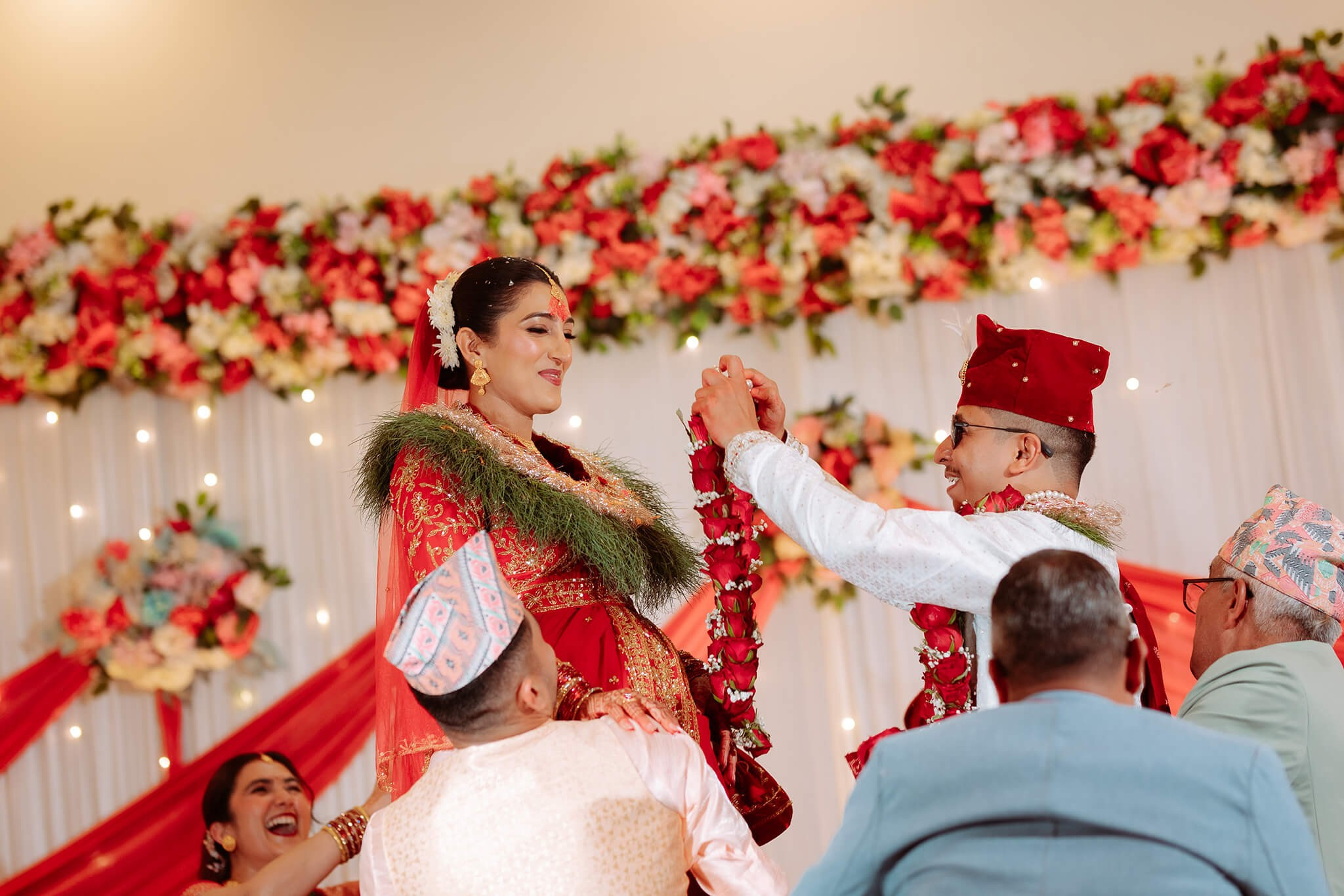 Nepali groom putting rose garland on bride during Barmala ceremony by Poudel Digital Photography Nepal.