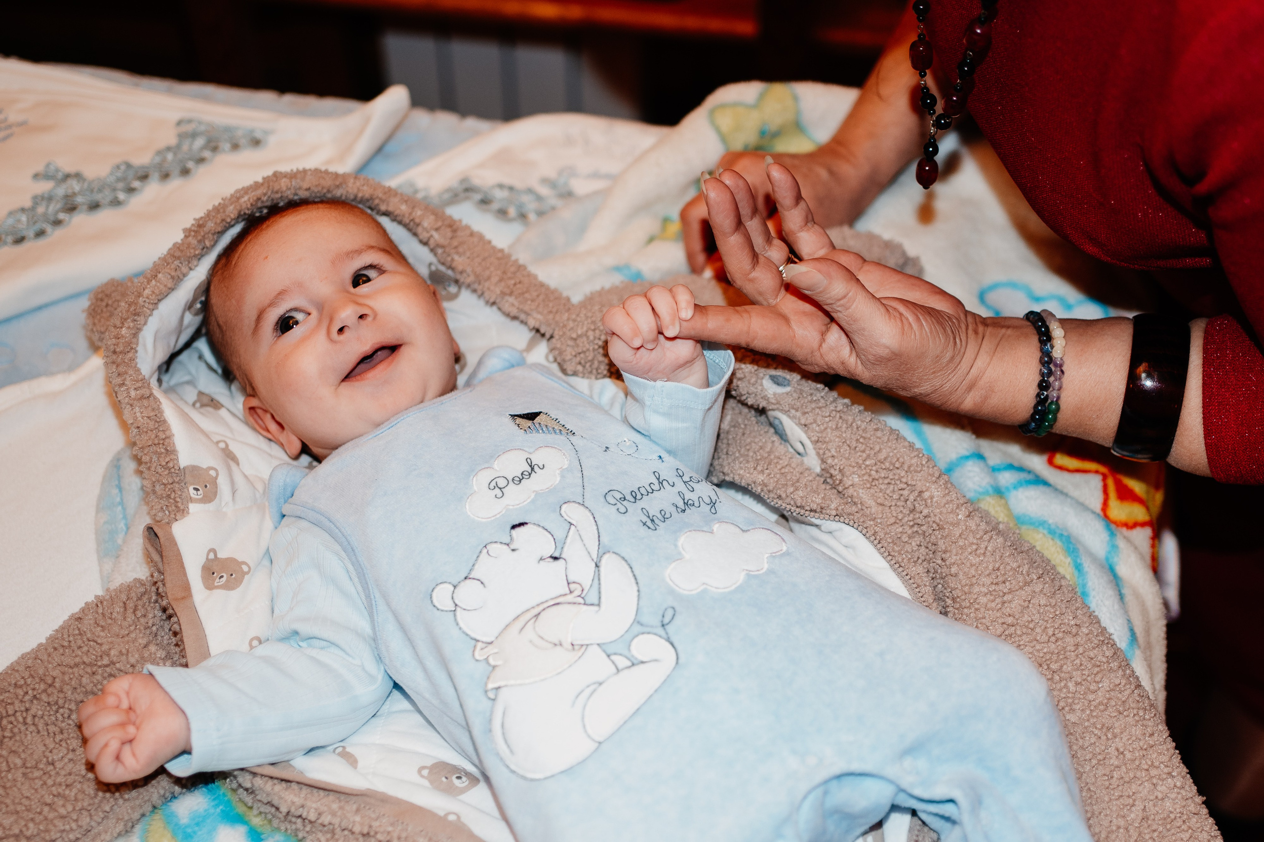 Instantaneu plin de tandrețe dintre părinți și bebeluș în ziua botezului, realizat în Bucuresti. Fotografie profesională de botez, capturând emoțiile autentice ale familiei într-un decor luminos și cald