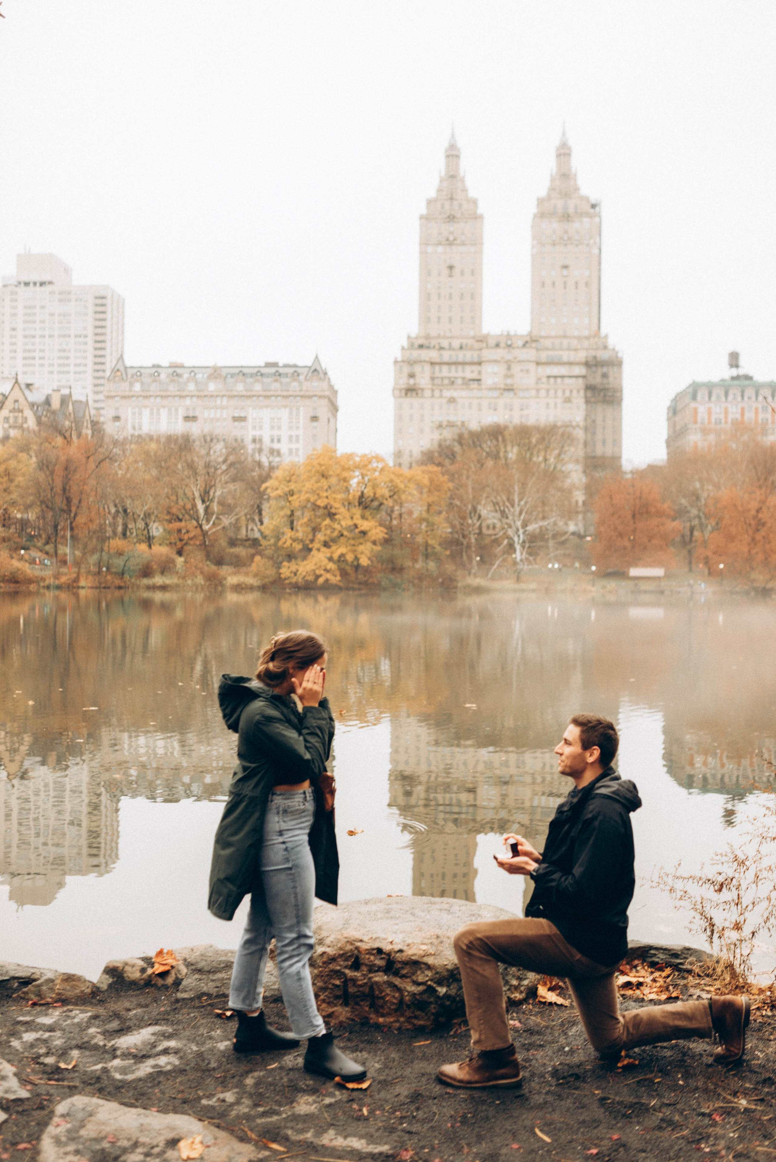 Man proposing in Central Park near Bow Bridge.