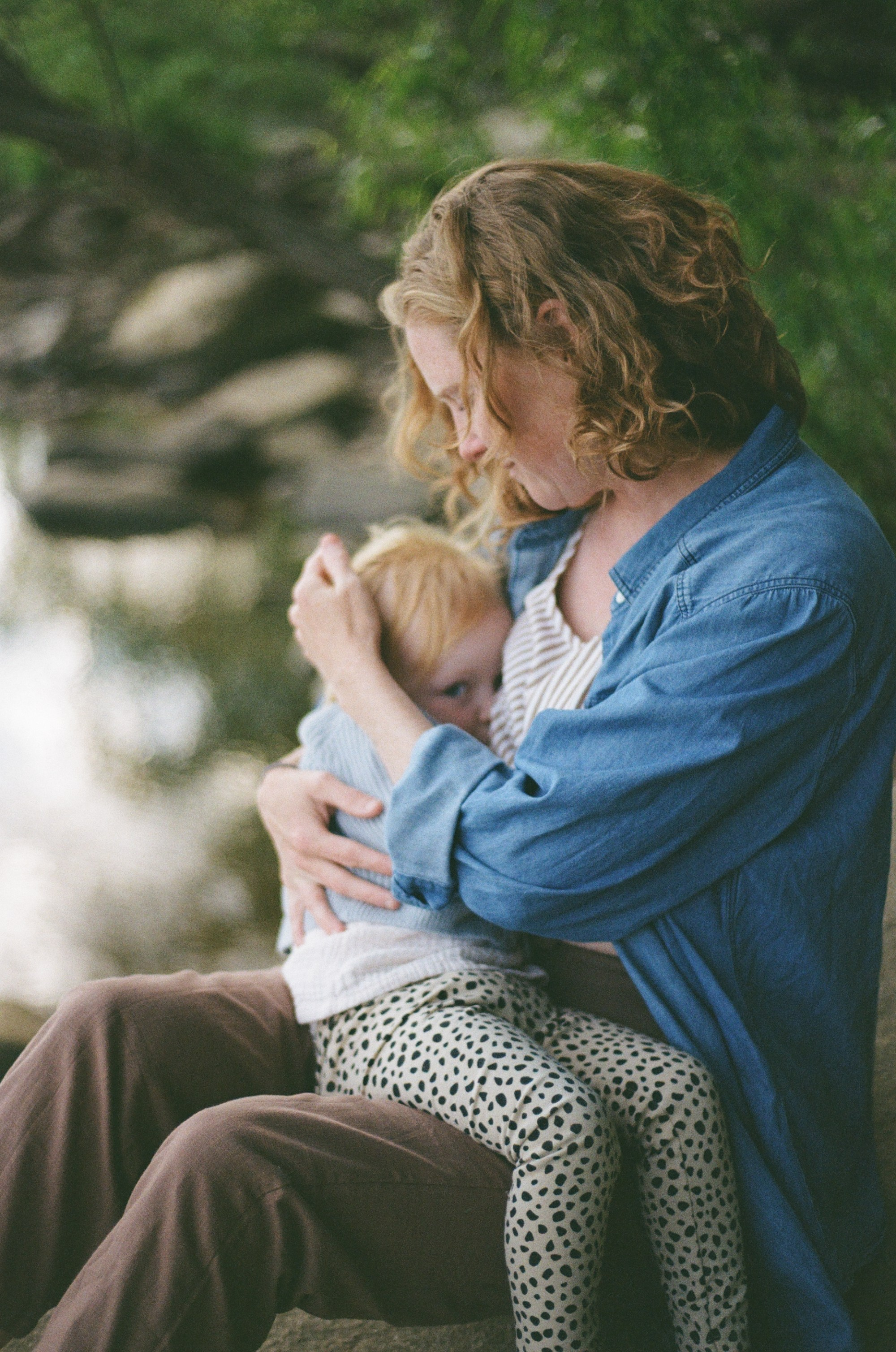 A mother and child sharing an unposed, artistic moment together by the water at the 42nd Street river entrance