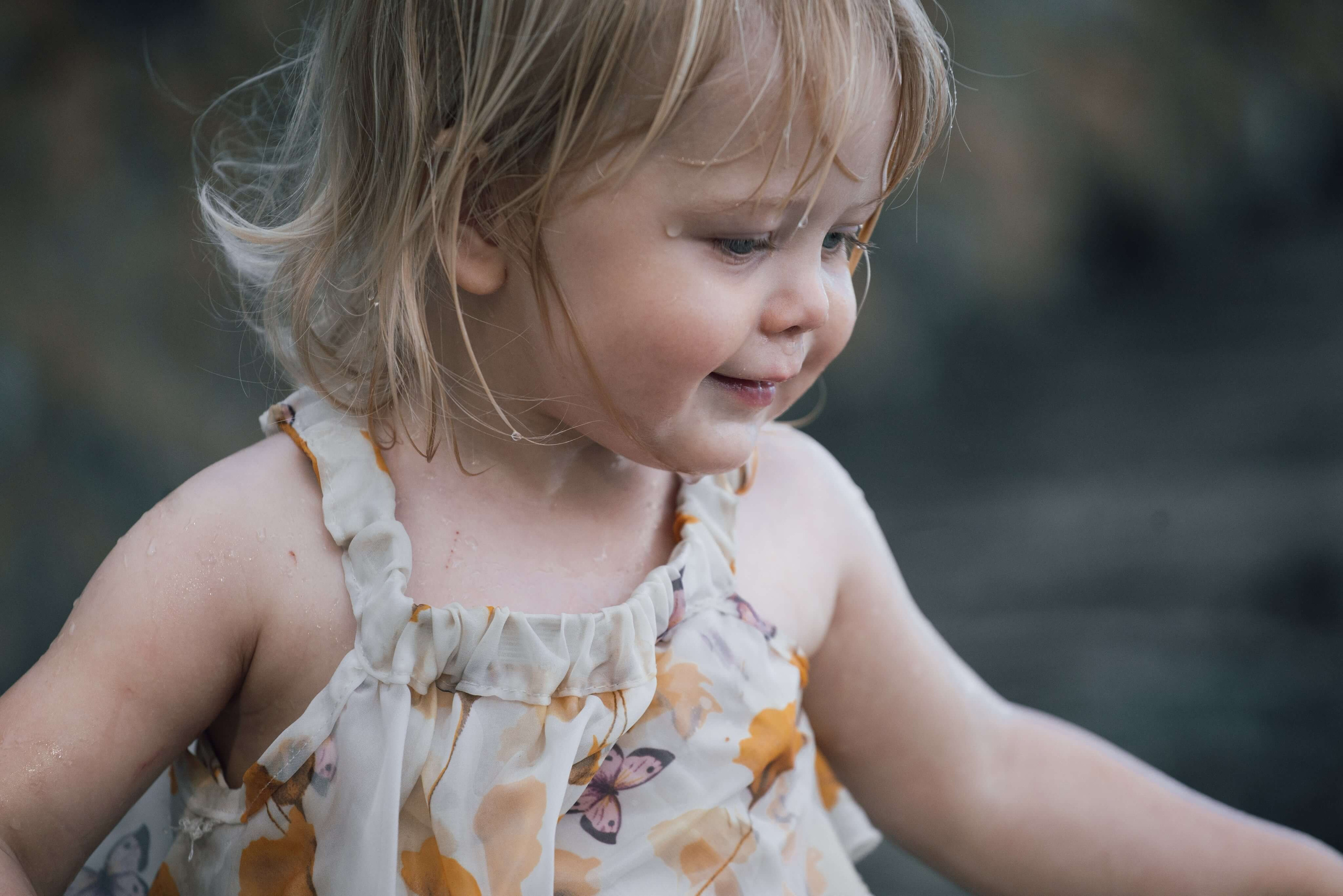 Barn som hopper fra en liten stein i vannet