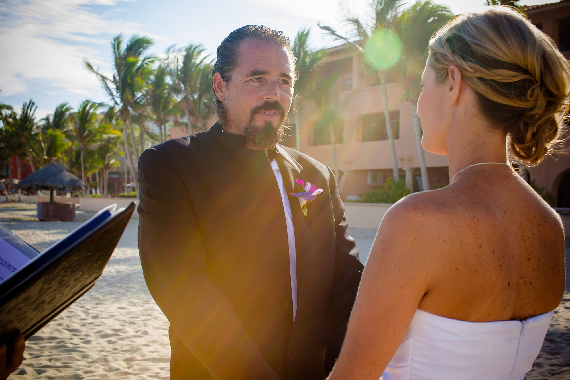 Wedding ceremony in Los Cabos – bride and groom holding hands saying vows by the ocean, cinematic destination wedding photography in Baja California Sur