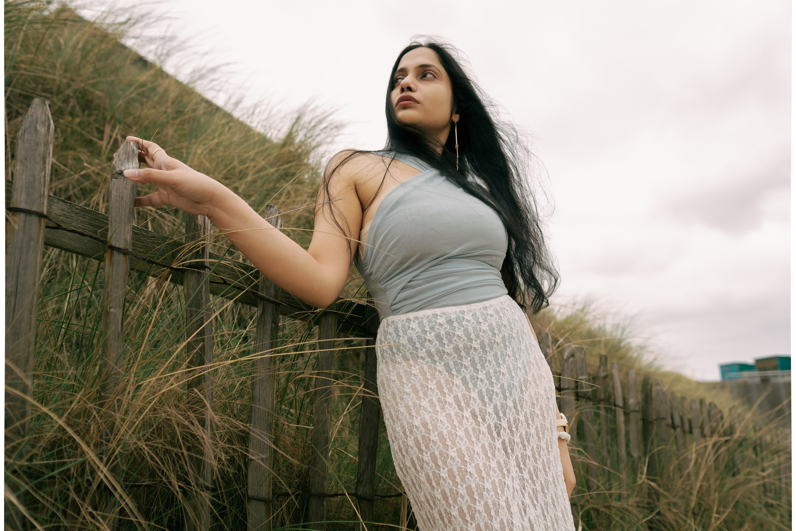 Fashion photoshoot in dunes with lace skirt and lace blue top