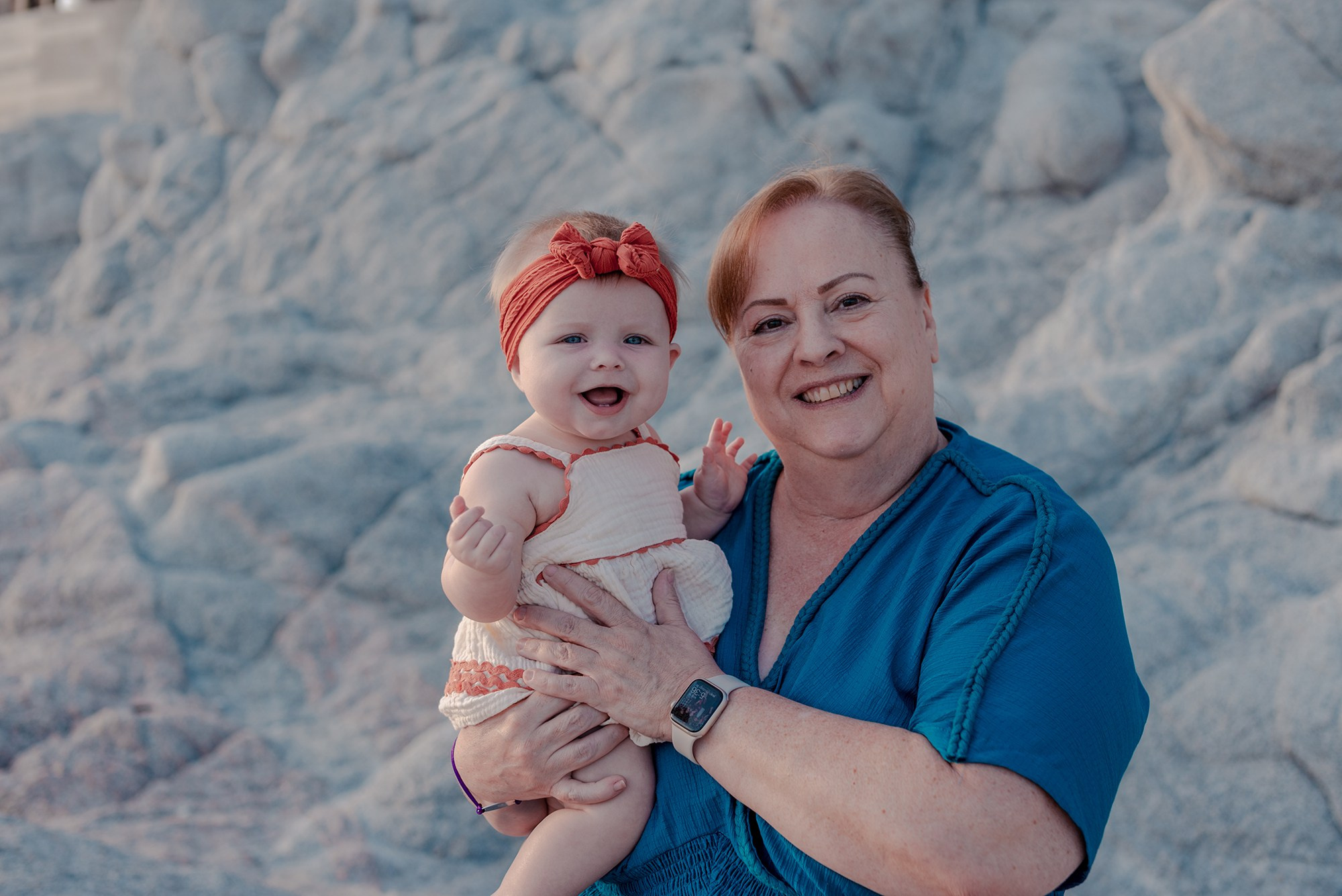 Multi-generational family portrait on the sandy beach at Playa Monumentos Cabo San Lucas during golden hour