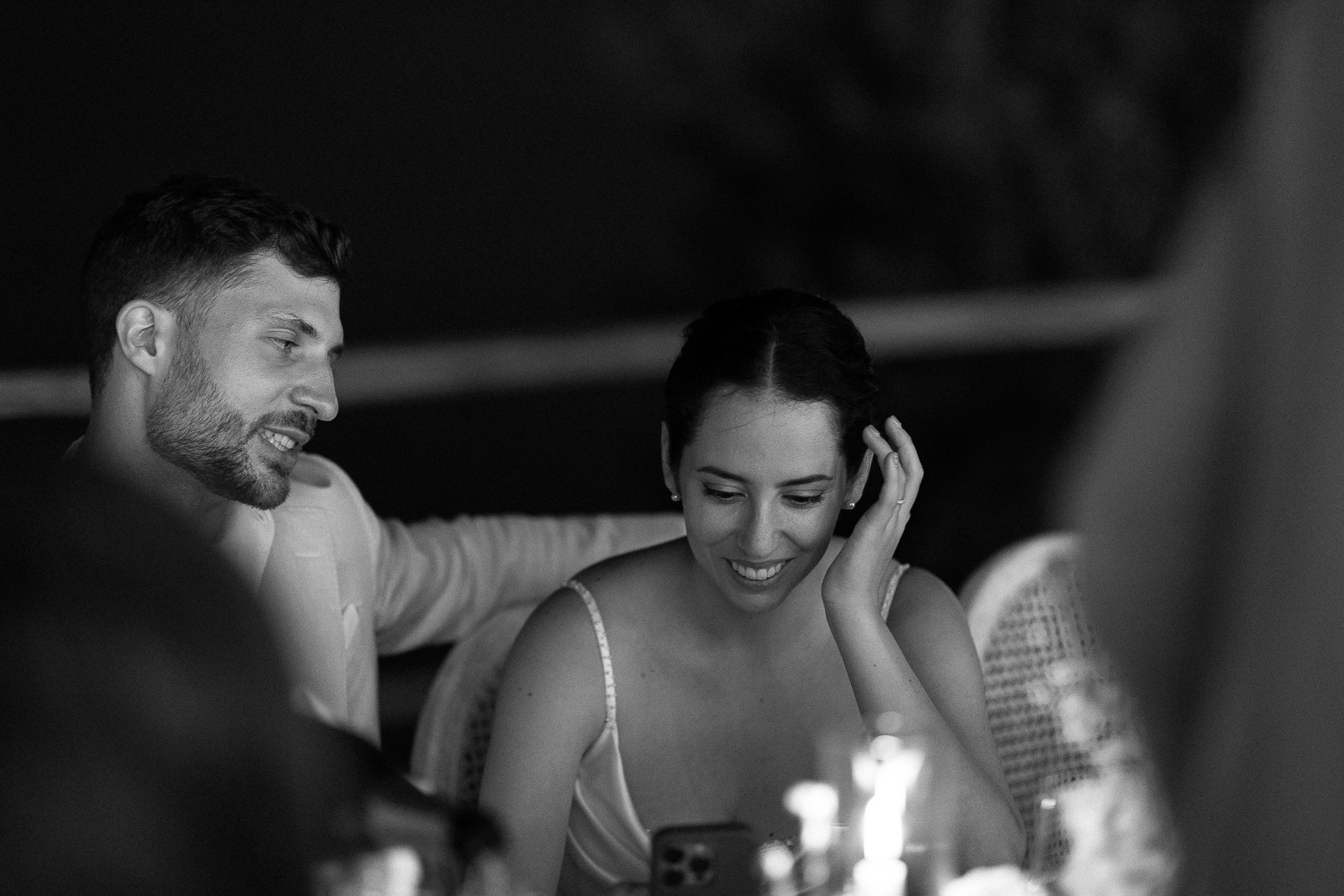 Bride laughing softly with groom at candlelit reception table, intimate moment at a Mallorca destination wedding
