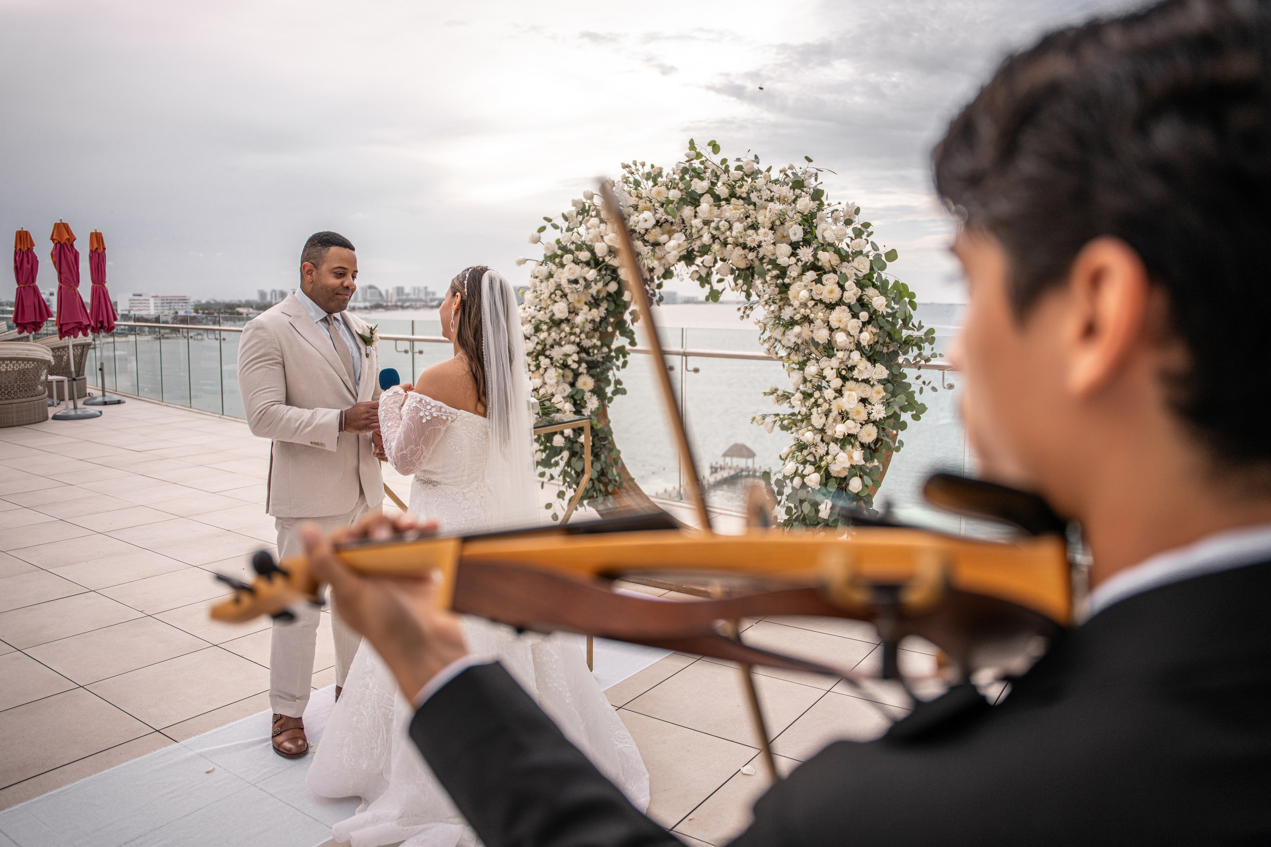 Vows exchange under floral arch in Cancun resort