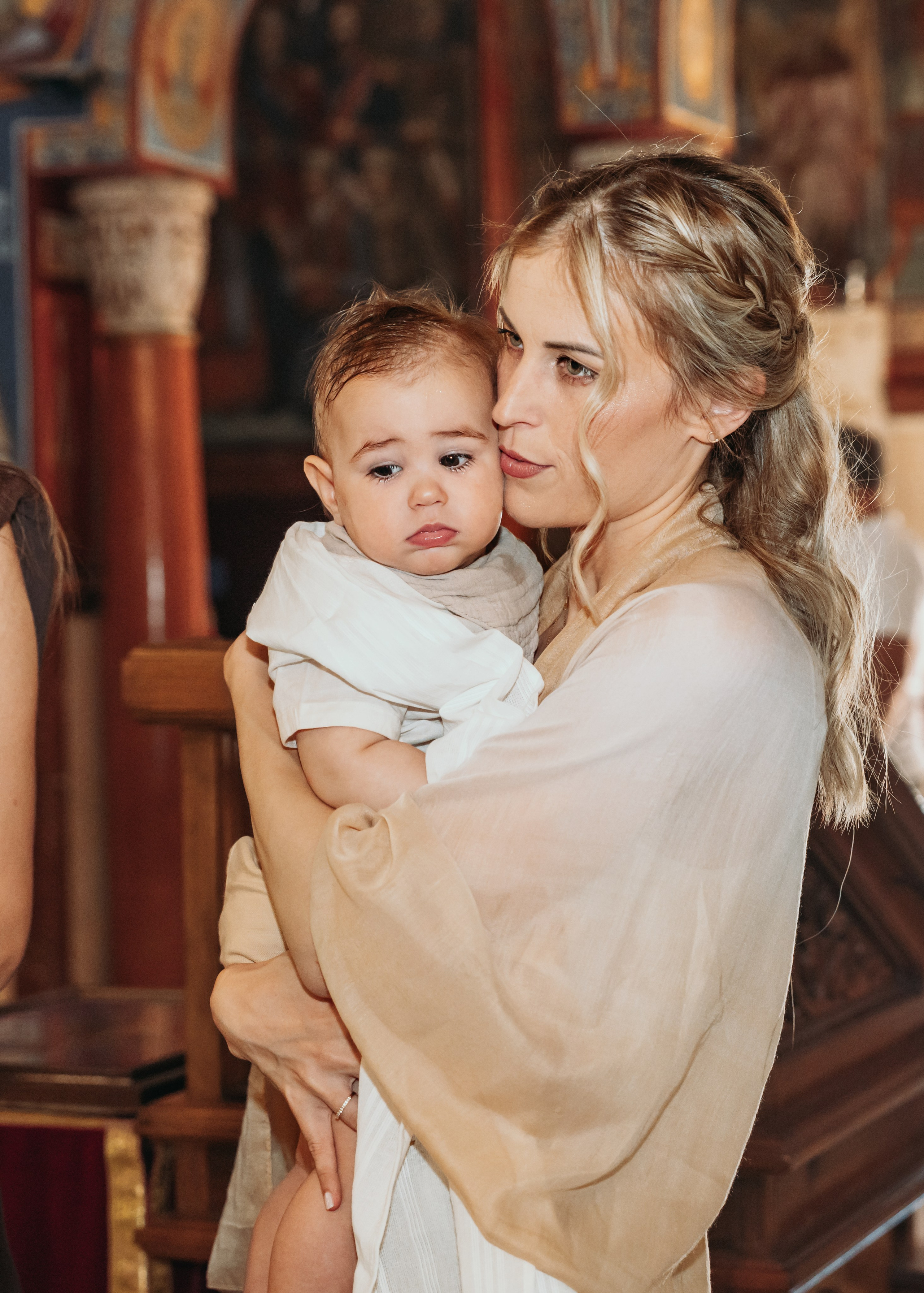 Beba u naručju roditelja tokom krštenja