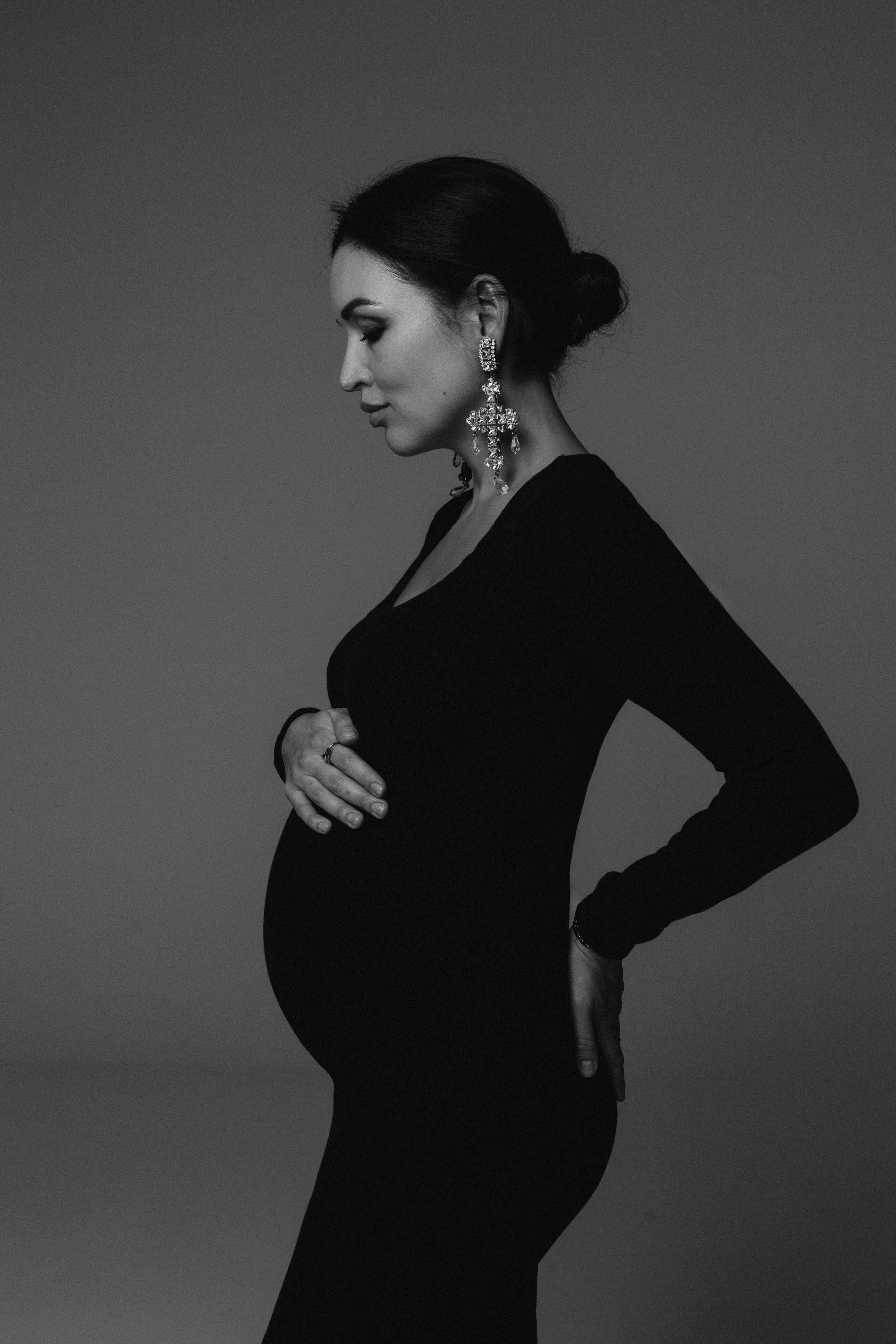 Ritratto in studio di donna incinta su sfondo neutro