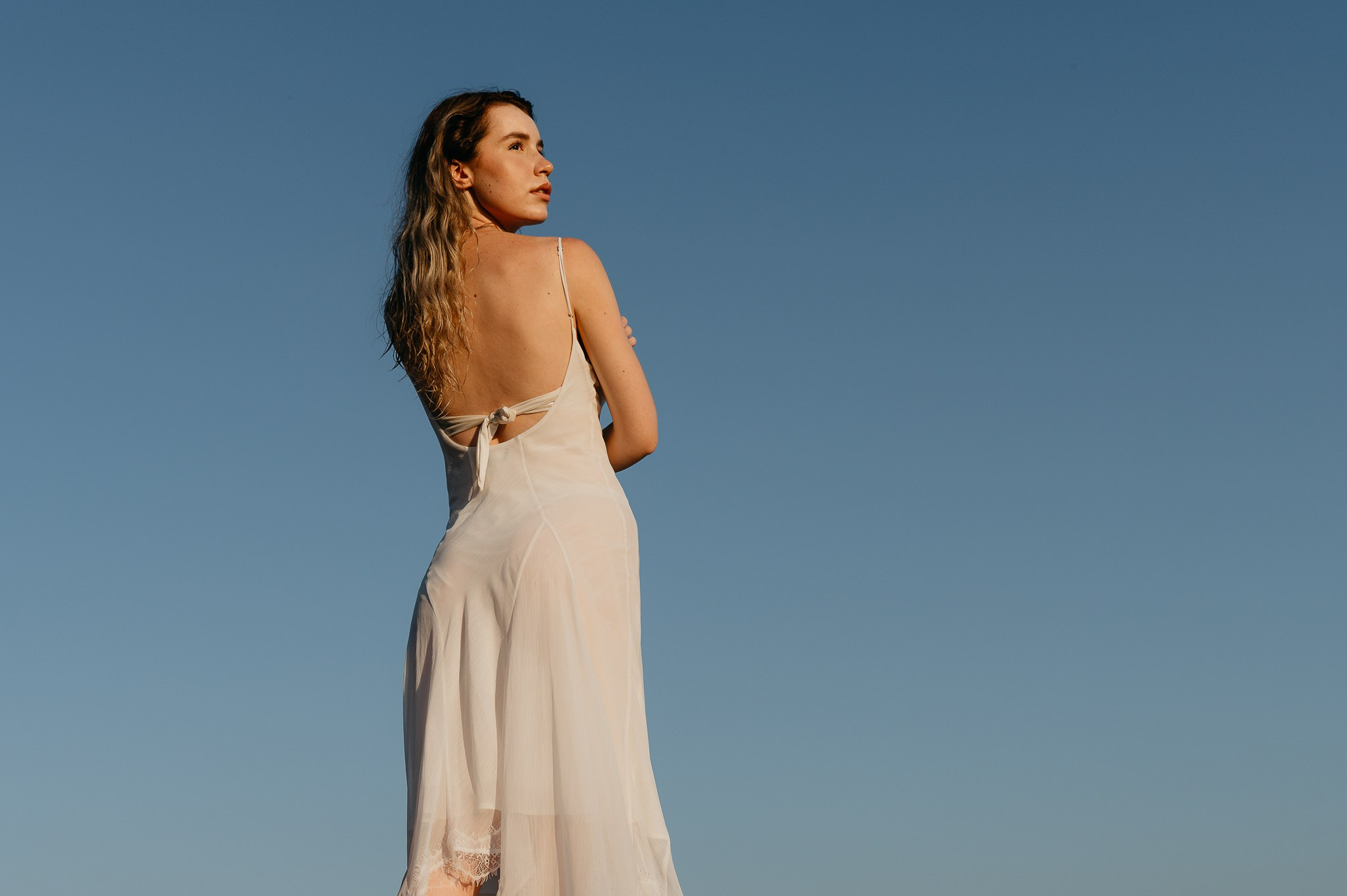 Model din spate, rochie albă, cer albastru intens, Slobozia