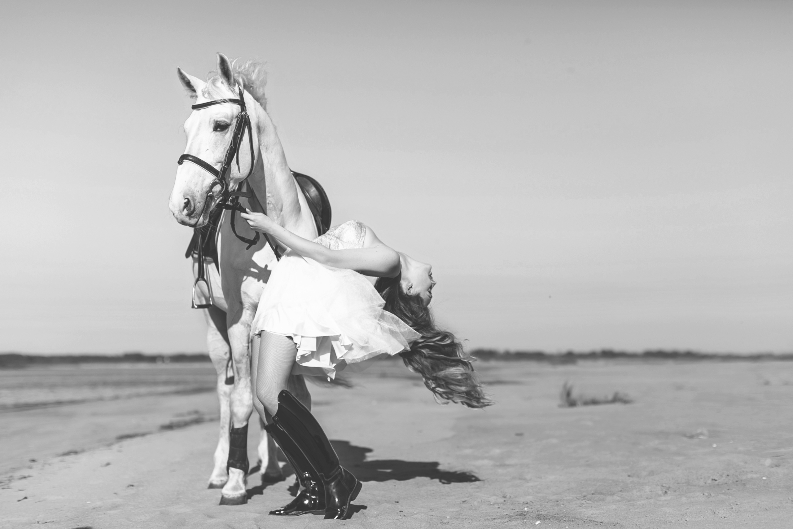Elegante Frau posiert bei einem Outdoor-Fotoshooting anmutig mit einem Pferd.
