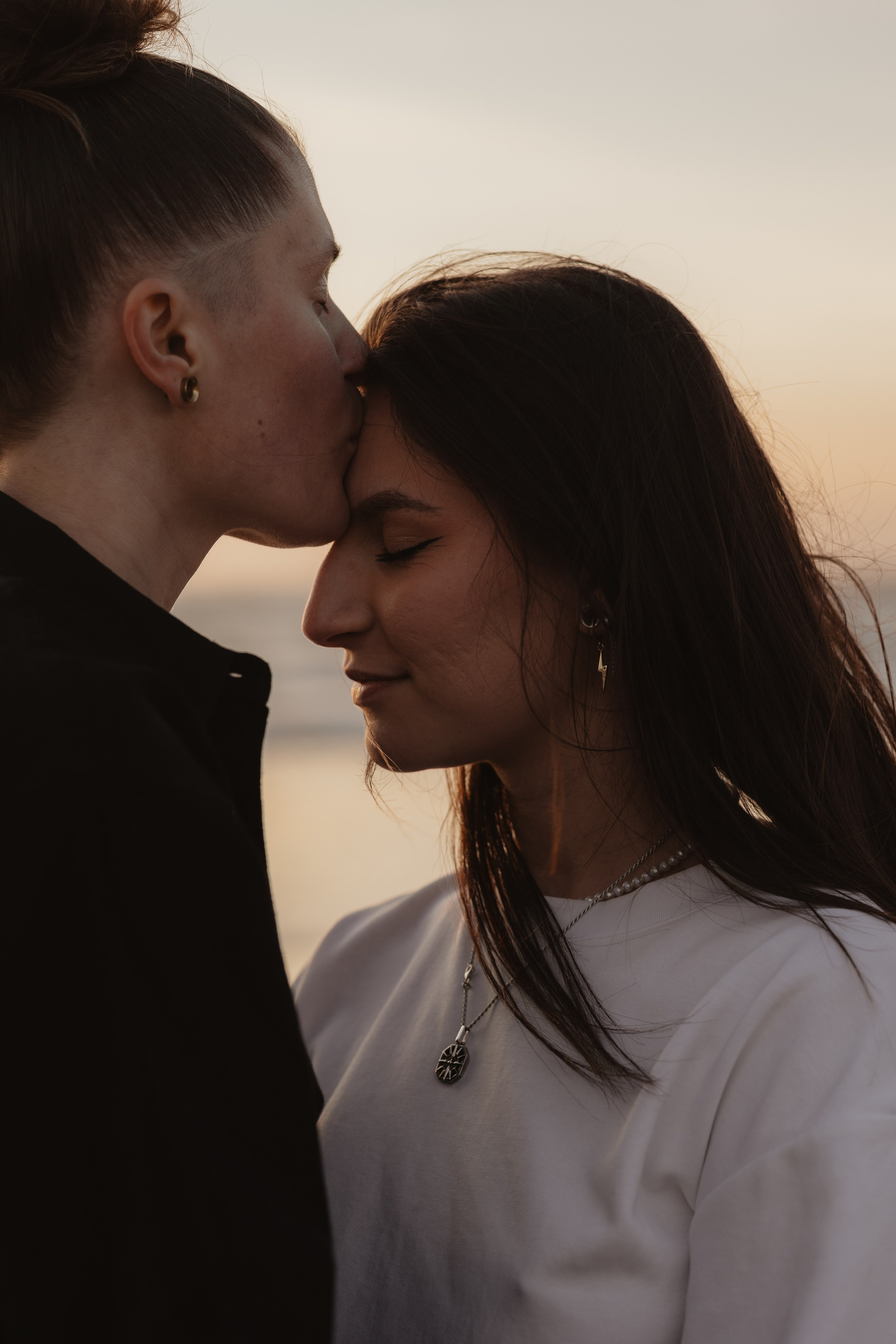 Deux femmes complices à la plage au coucher du soleil, photographie de couple naturelle