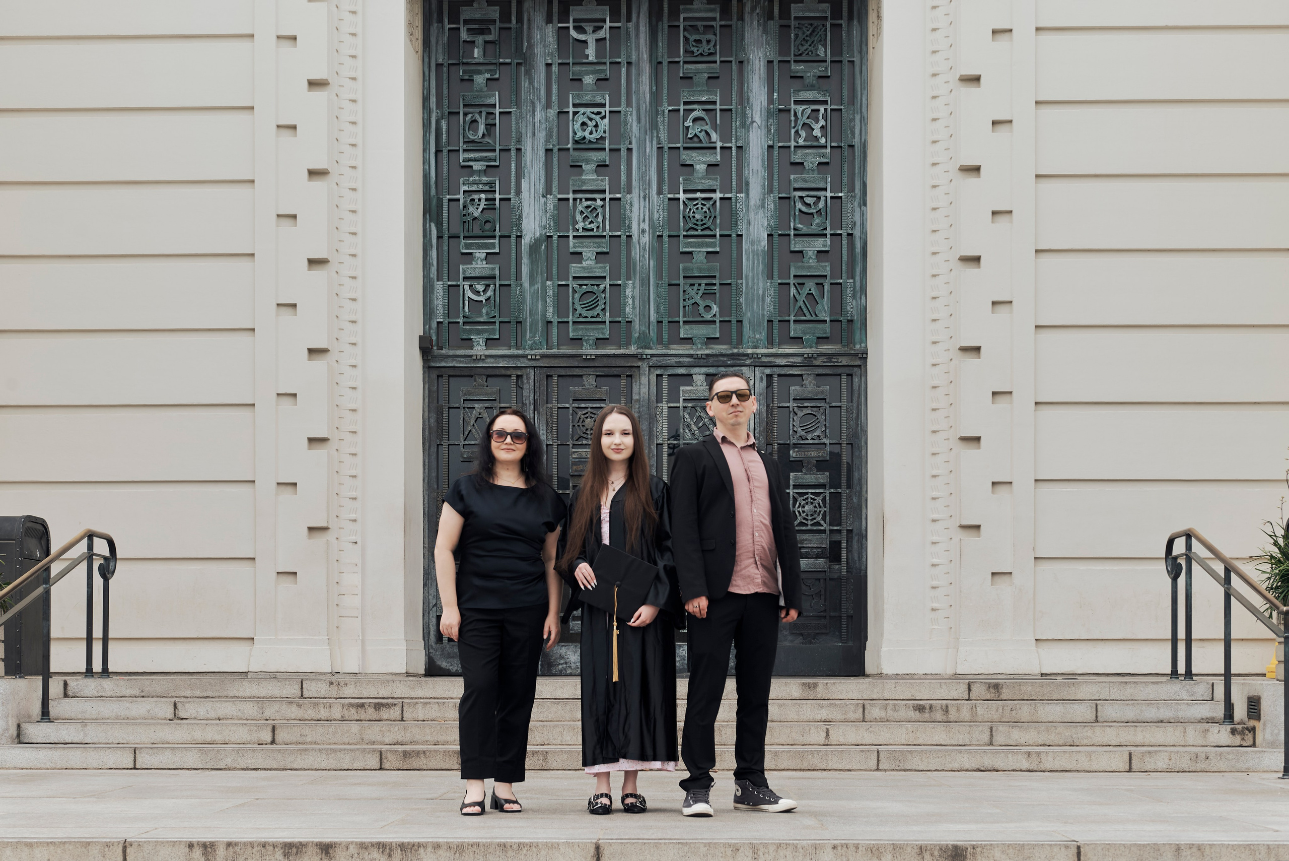 Formal graduation photo of a student in cap and gown on a picturesque Los Angeles beach
