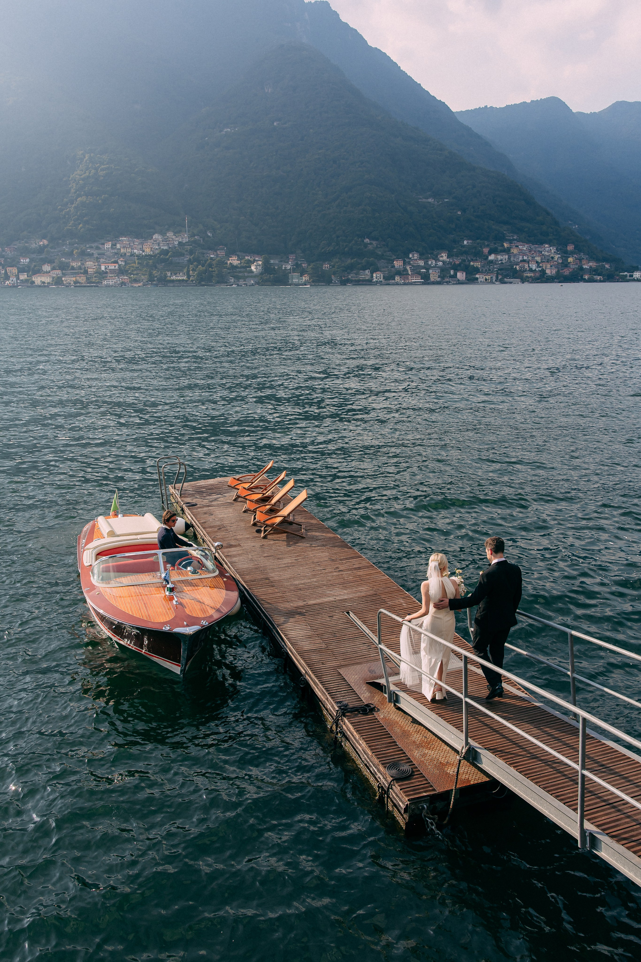 Classic wooden boat waiting at the dock on Lake Como near Villa Lario, Italy