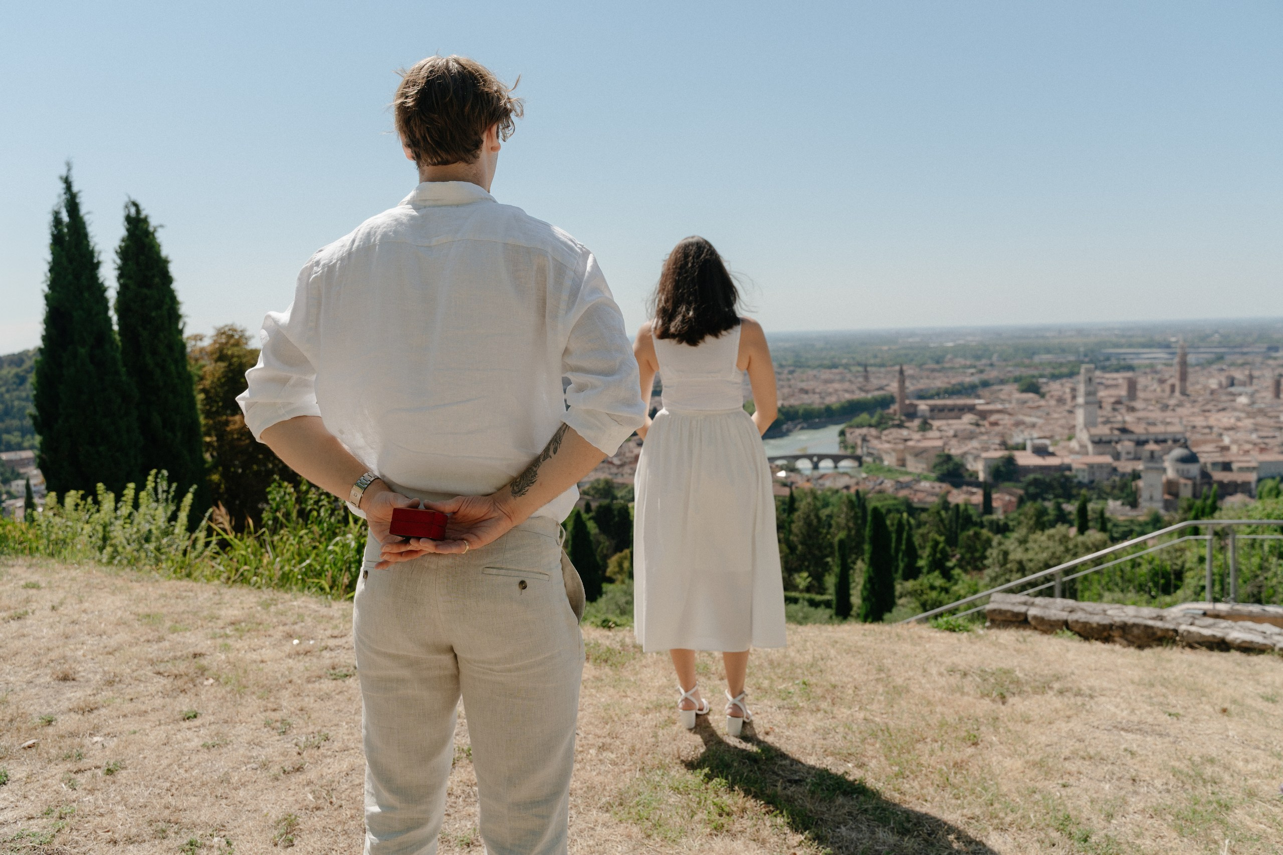 Surprise proposal in Verona captured from a scenic viewpoint with the historic city in the background.